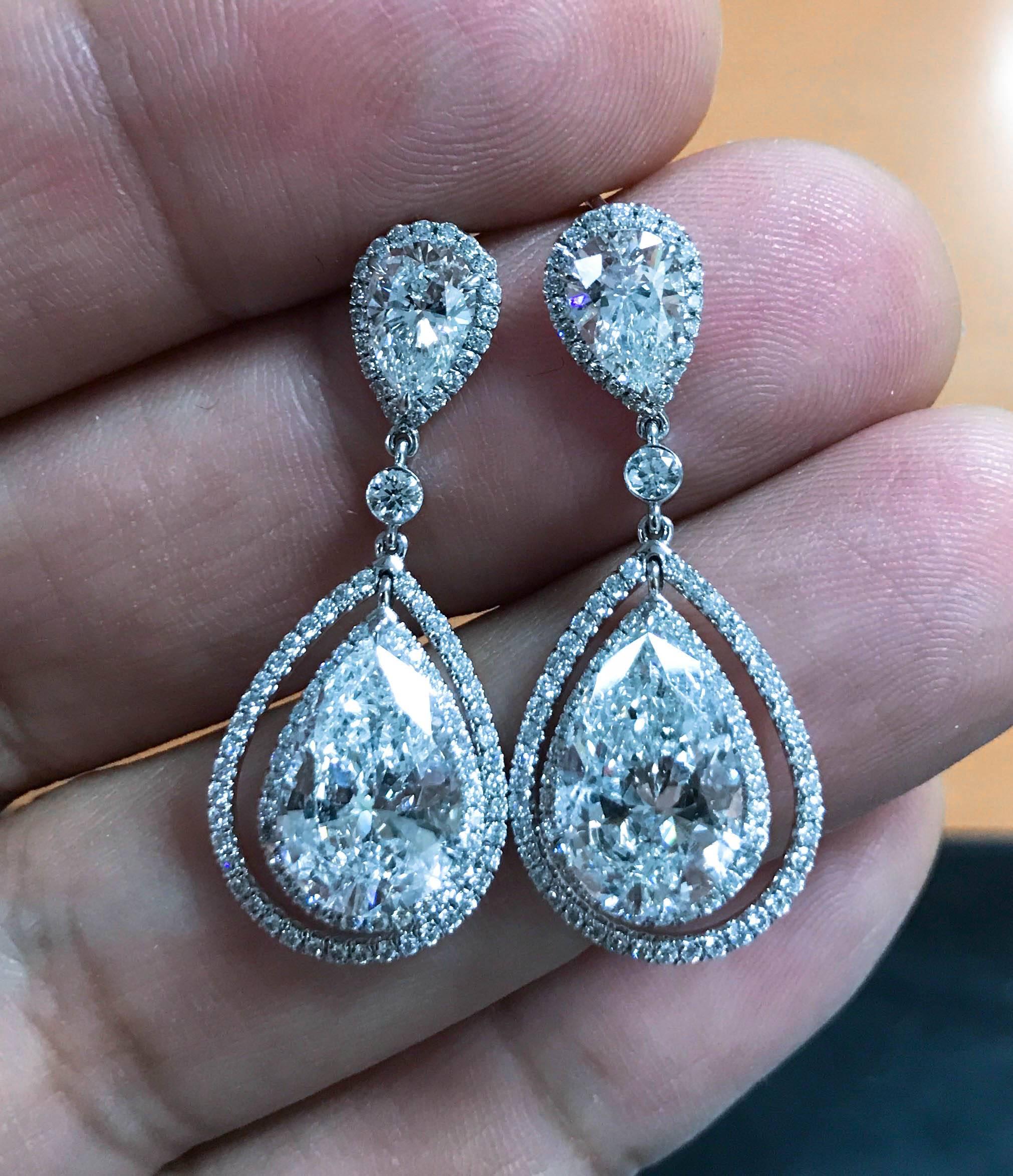 Pair of dangling earrings with 2 perfectly matched pear shape diamonds in a double Halo design. 
Larger centers weigh 6.54 Cts total , F-G Color , SI2-SI3 clarity.
Smaller centers weigh 1.58 cts total, F-G Color and SI2-SI3 clarity.
Total diamond