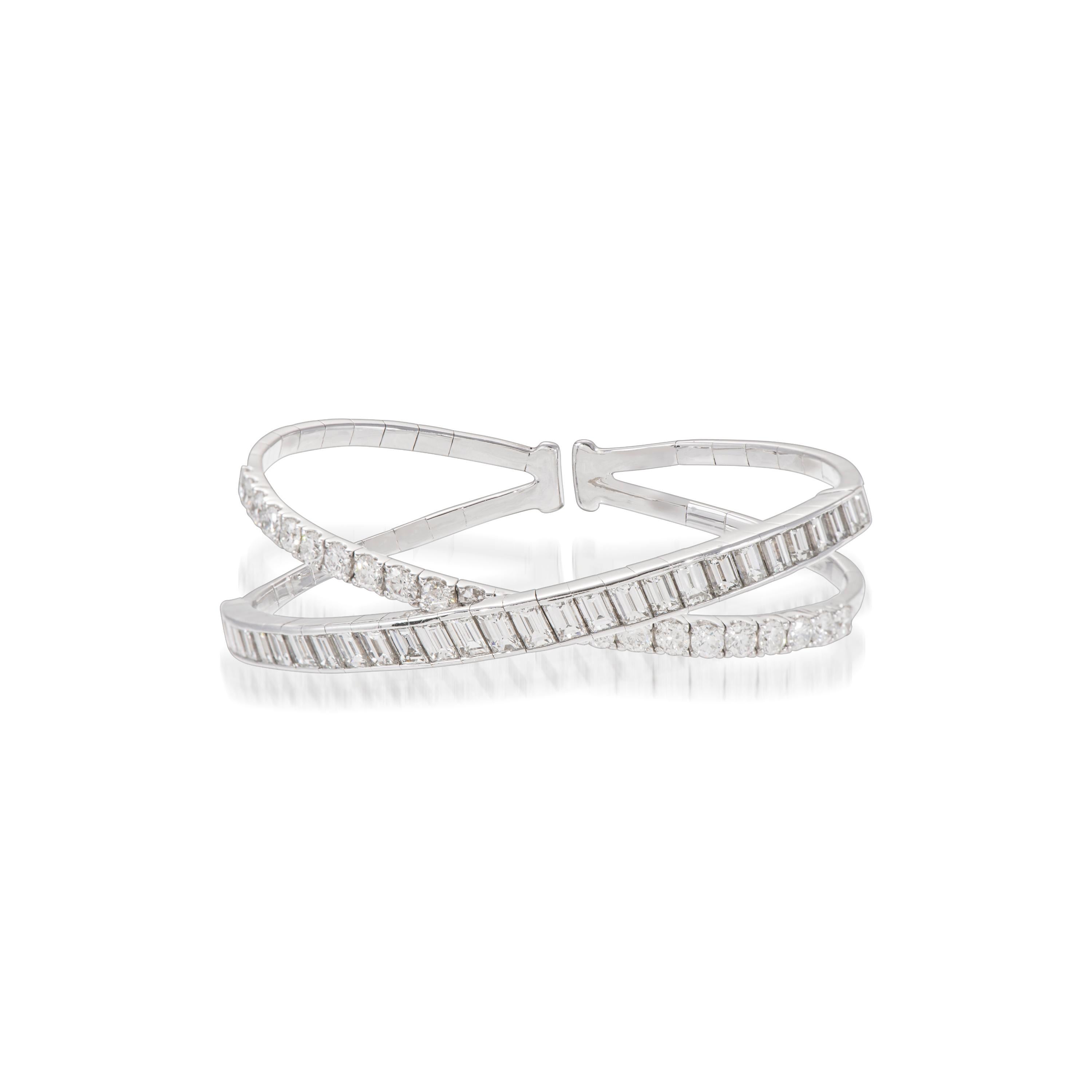 This cuff bangle bracelet is crafted in 18K white gold and encrusted with one band of sparkling baguette diamonds and one band of brilliant round diamonds totaling 9.09 carats. The clean and modern criss-cross design creates intentional space so