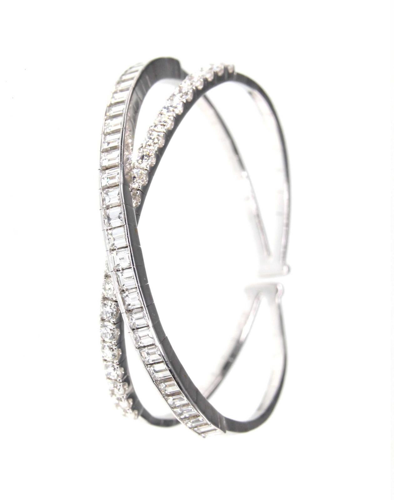 This cuff bangle bracelet is crafted in 18K white gold and encrusted with one band of sparkling baguette diamonds and one band of brilliant round diamonds totaling 9.09 carats. The clean and modern criss-cross design creates intentional space so