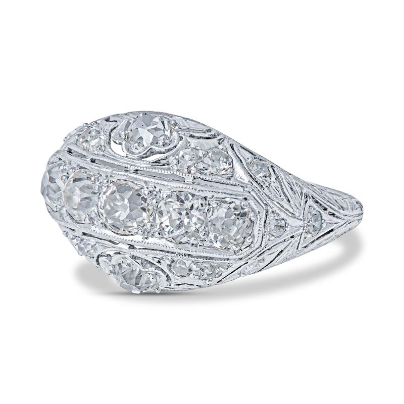 An antique ring crafted from platinum and features .90 carat total weight of Euro cut diamonds and filigree detailing. The diamonds are G-H in color and VS1-VS2 in clarity. This ring is a size 5.75. 