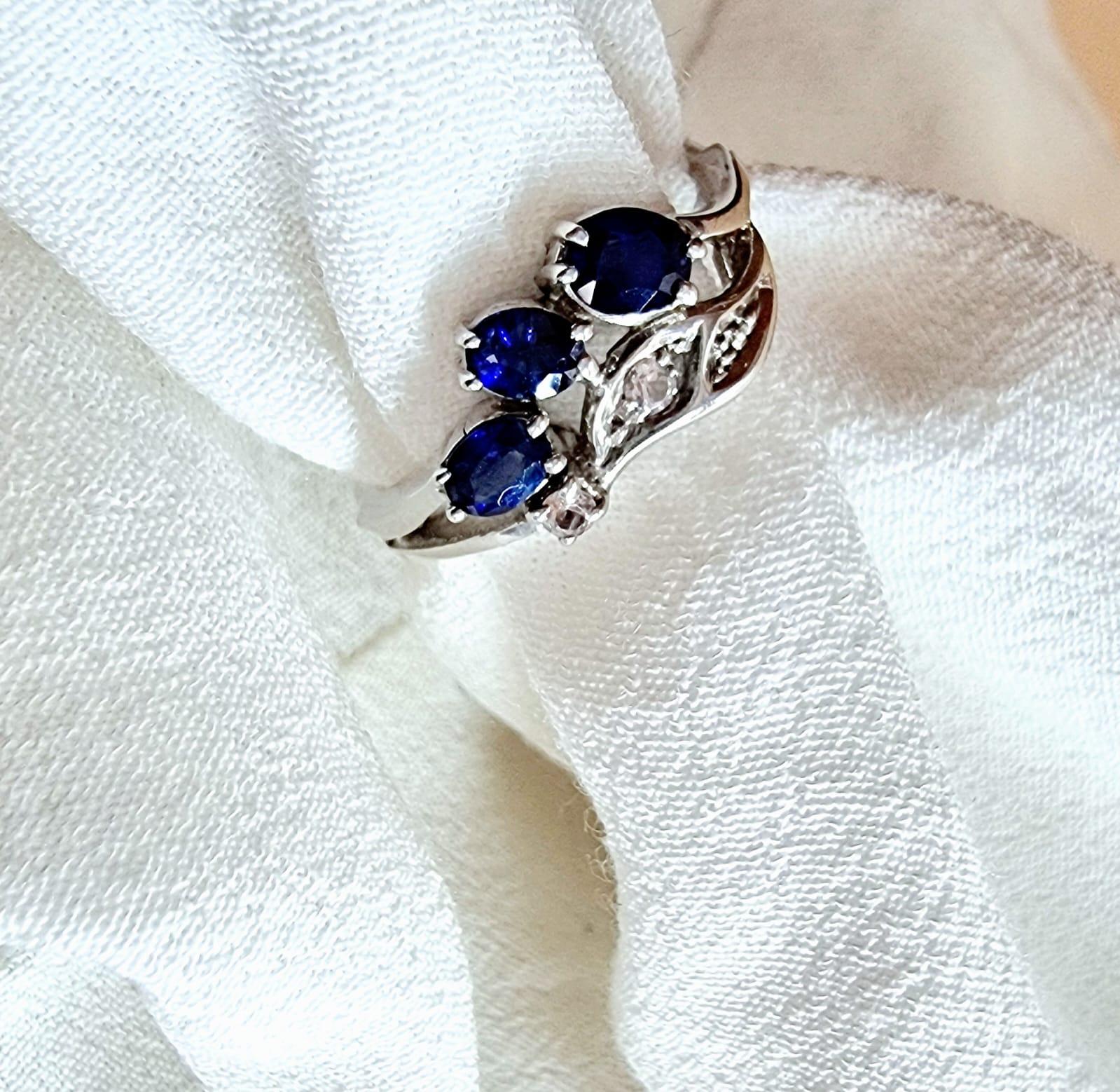 Introducing our .9CTW Oval Blue Sapphire Platinum Silver Vintage-Inspired Leaf Design Ring, a stunning piece that exudes elegance and sophistication. This ring features a mesmerizing 3x .3ct Oval Blue Sapphire design, known for its captivating blue