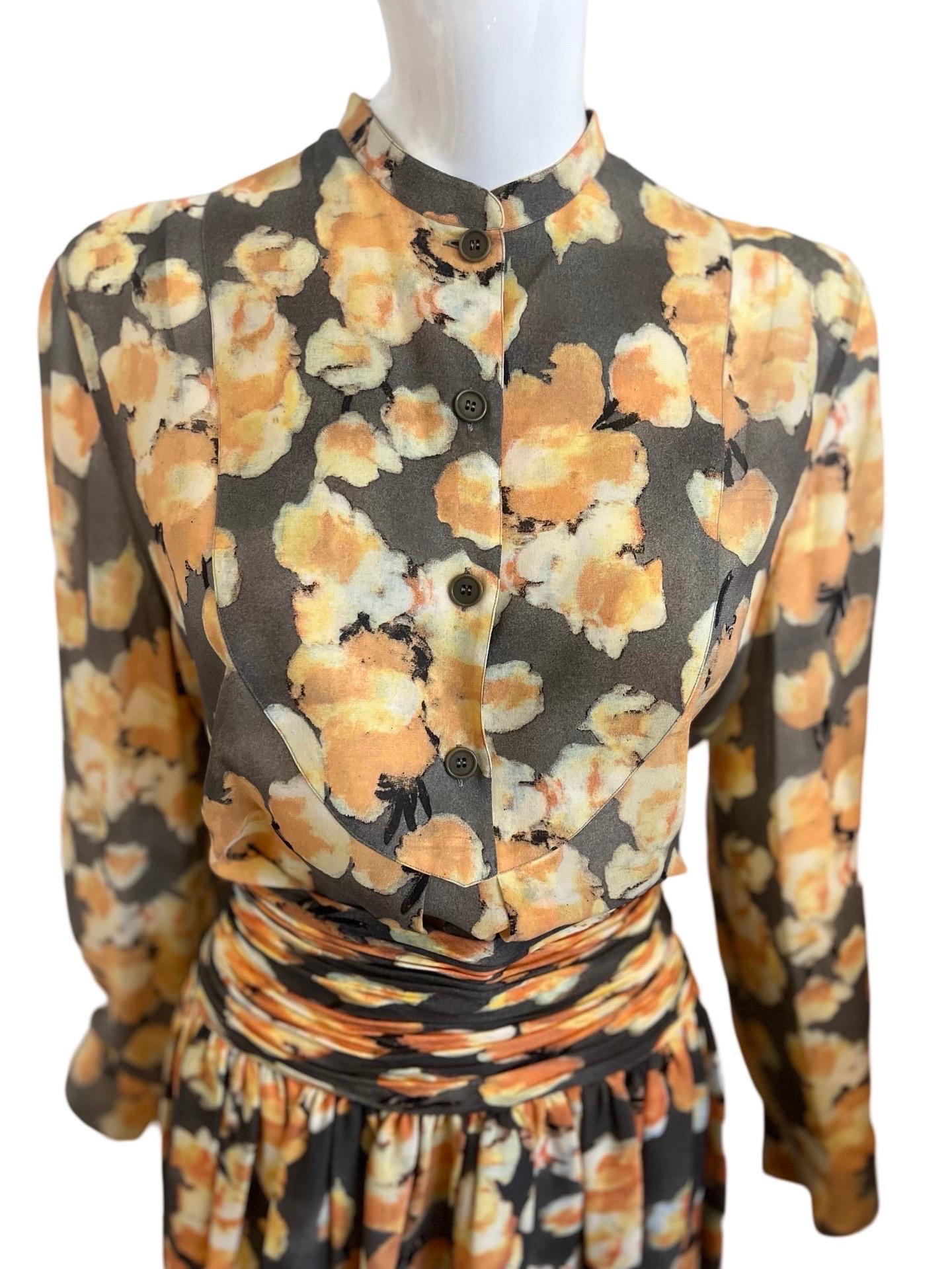 Classically beautiful Giorgio Armani Set in a flowy floral fabric of orange flowers which look screenprinted, set on a grey background.  The top has a tuxedo style bib, buttoned halfway down and no collar with slightly ballooning sleeves and almost