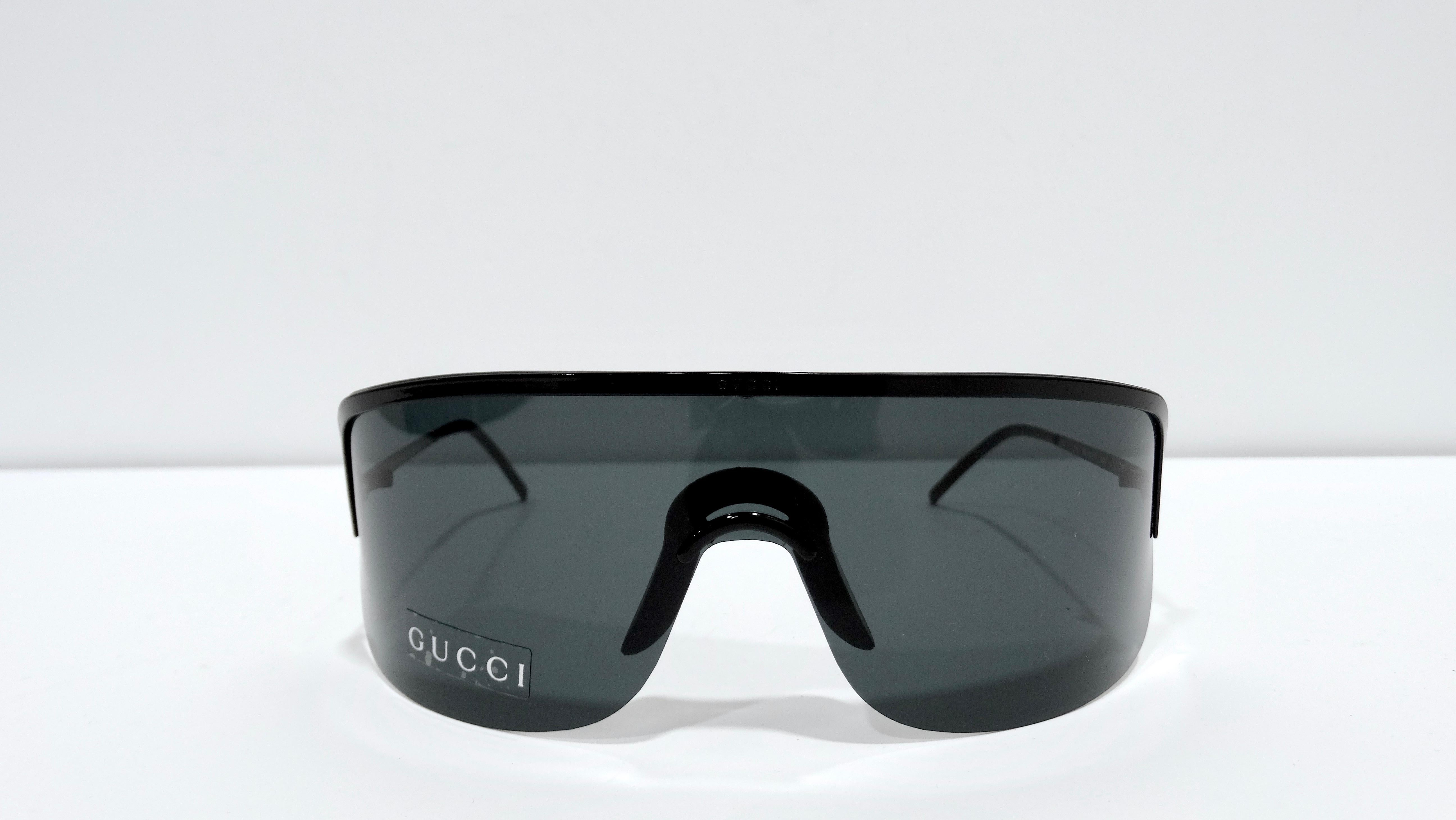 Feel your coolest self in this oversized Gucci shielded sunglasses. You will feel like a fashion icon every time you wear them These feature a thin black temples, a simple pairing of black hardware and black lenses, and an embossed 