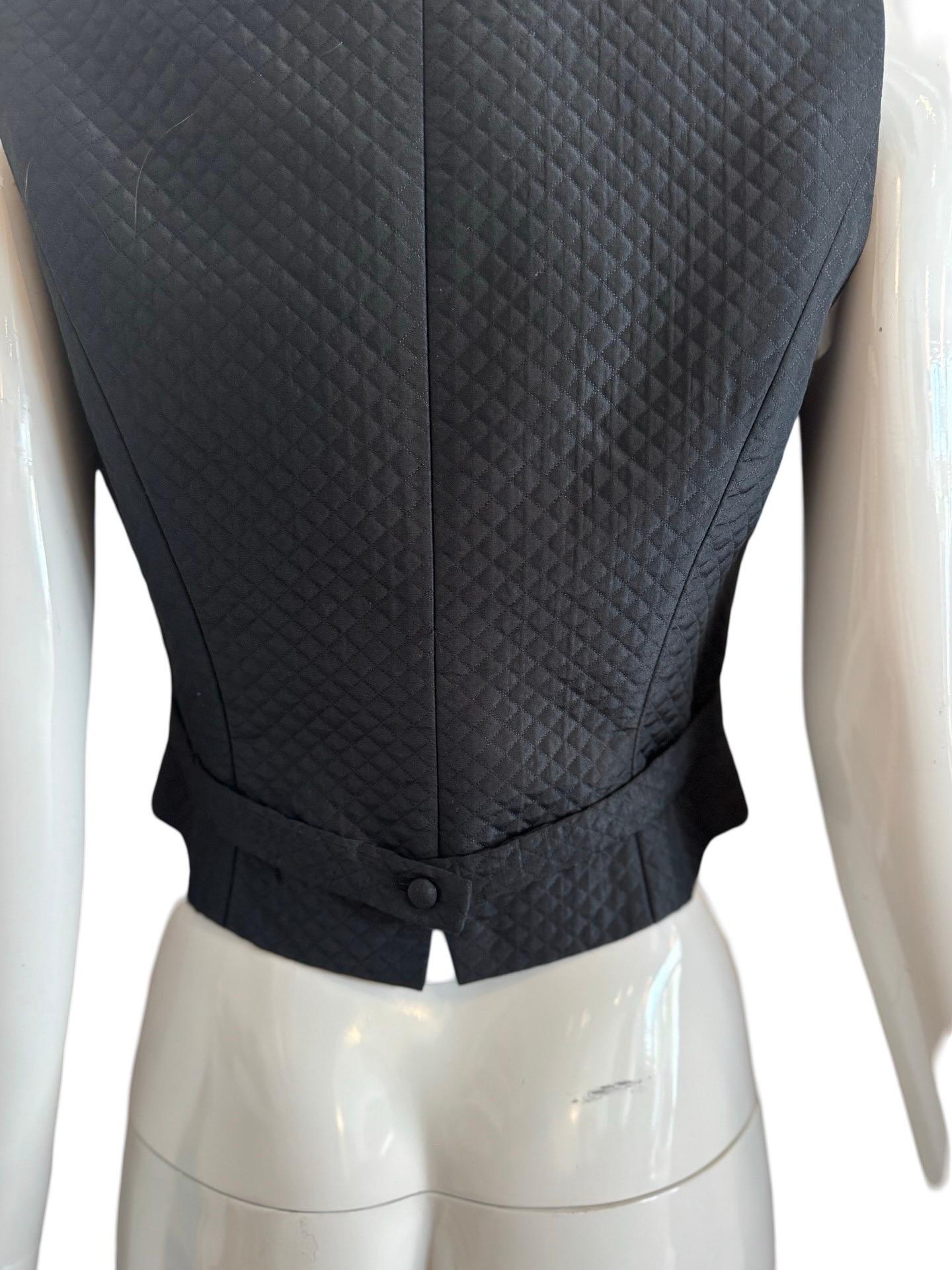 Very chic quilted equestrian style vest from 90s Kenzo Paris.  Made from a silk blend with small detailed quilting and matching fabric covered buttons.   Lined in Polyester.   Labelled  FR40.

Length 20.5