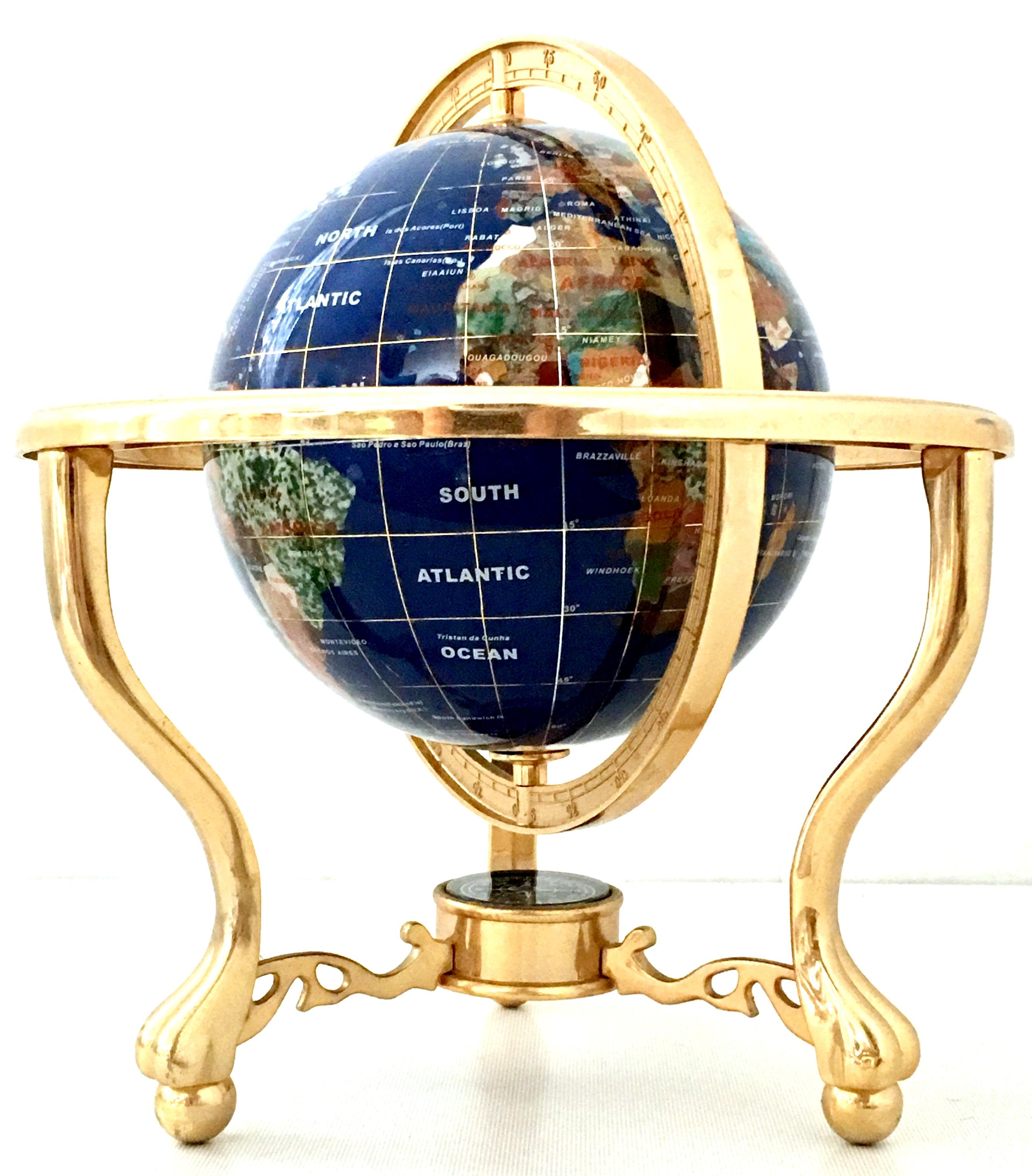 1990s blue Lapis Lazuli, gemstone and 24-karat gold plate tripod Stand world globe. This 9'' inch world globe features an authentic blue lapis ground with each country hand carved of multiple semi precious gemstones. There is 24-karat gold inlay