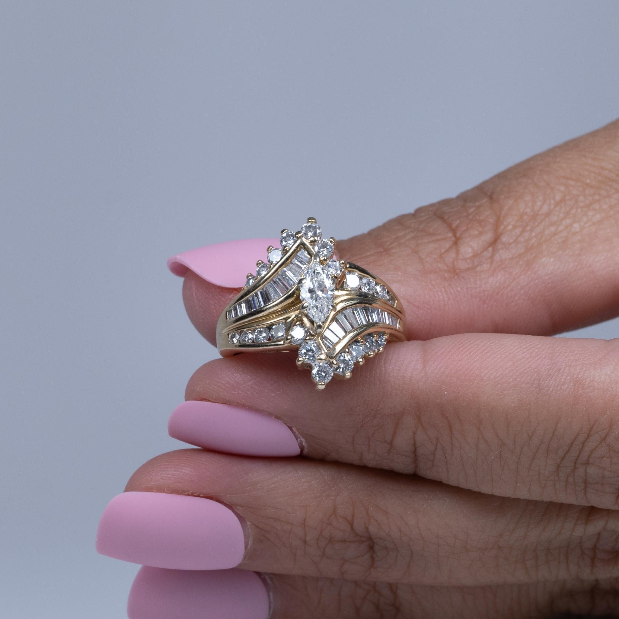 This vintage 90s ring showcases a stunning marquise-cut diamond at its center, set in 14k yellow gold. Flanked by sparkling baguette and round-cut diamond accents, the ring exudes a timeless elegance and sophisticated charm. The combination of the