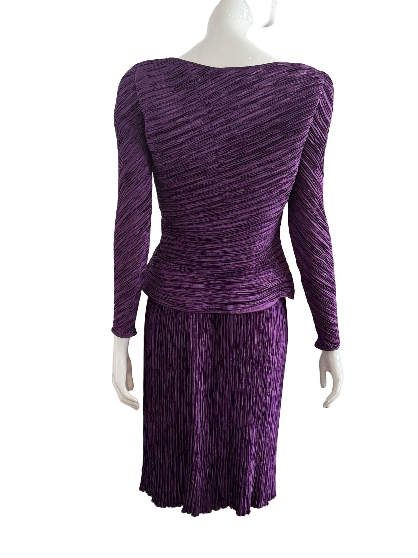 Beautiful Mary McFadden Couture deep purple set in her classic plisse design.  The set has a rolled hem design that flares out slightly at the bottom of the top.  The skirt is unlined with a zipper closure.

Some pulls and fraying at points over the