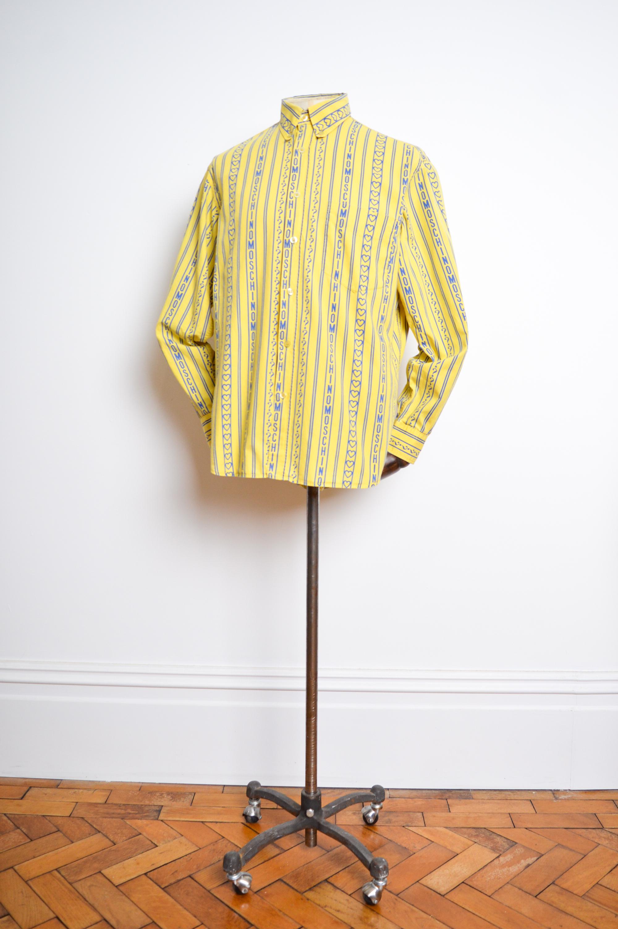 Early 1990's UK Garage Era 'MOSCHINO' repeat patterned Long sleeve Shirt, crafted from a printed rayon in Pale Yellow and Sky Blue shades. 

MADE IN ITALY.   

Features: Logo spell out print, button down front, Collar, Long sleeves, cuffs, embossed