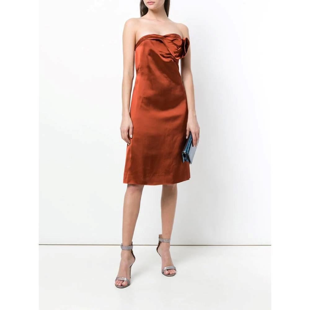 Strapless rust-coloured silky effect Versace dress. Draped neck and flared cut. Rear zip fastening.

Size: 40 IT

Flat measurements
Height: 85 cm
Waist: 35 cm

Product code: A7208

Composition: 100% Acetate

Made in: Italy

Condition: Very good