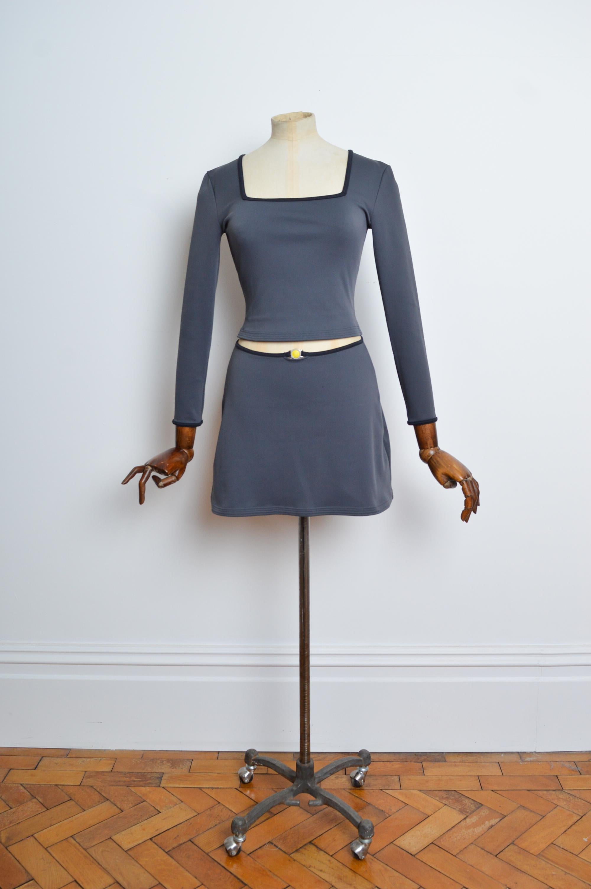 VERSACE Intensive Charcoal Grey Medusa Fitted Top & Mini Skirt - Twin Set.
Circa Late 1990's.
Features: A Fitted figure hugging Top with long sleeves and squared neckline with complementing Mini skirt, both bearing the iconic ‘Medusa’ detail in