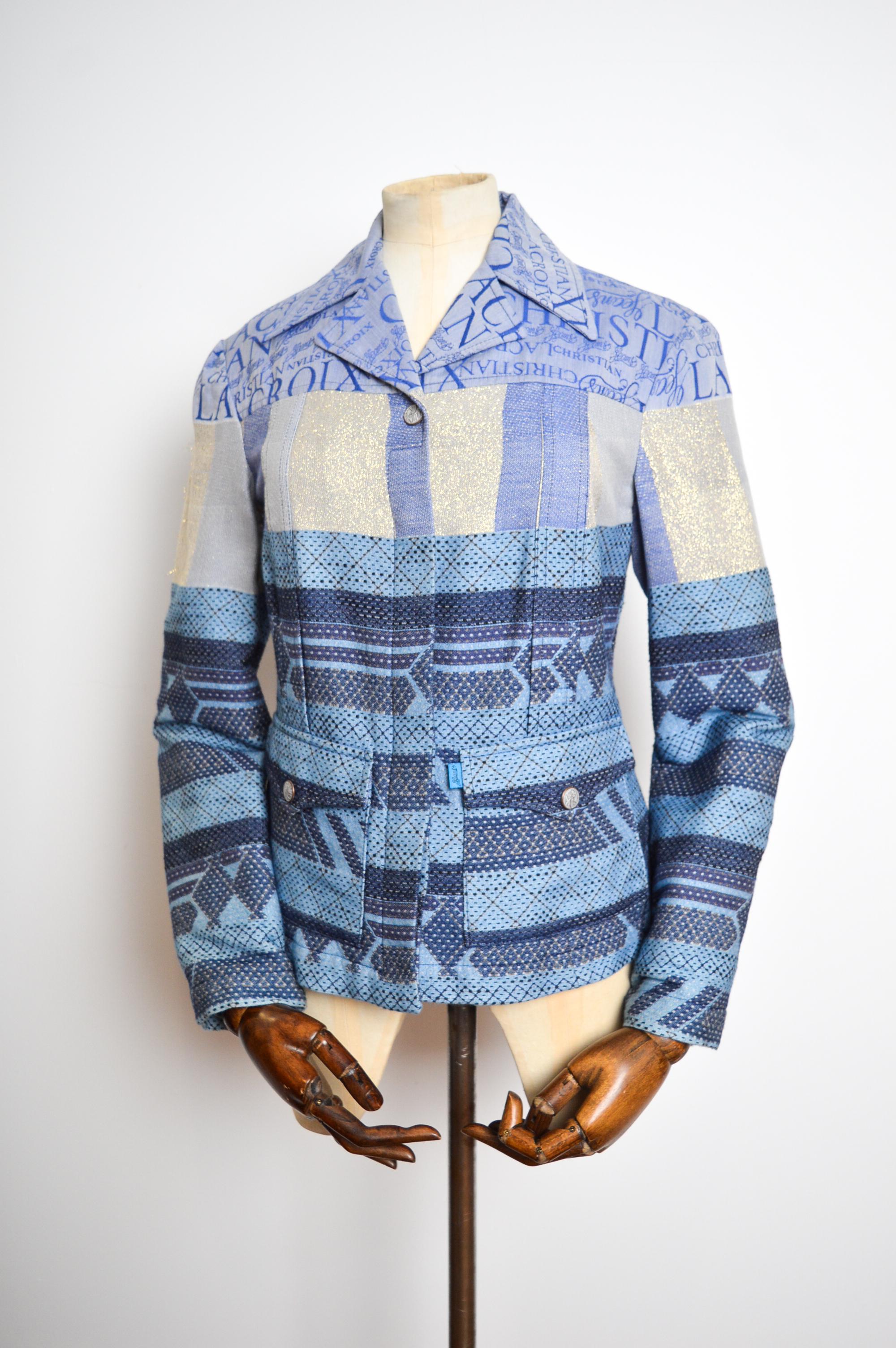 1990's Vintage Jacquard Monogram Jacket by Christian Lacroix, in a beautiful intricately crafted blue jacquard cloth featuring a simple long sleeve, button down design. 

The Jacket has belt loops at the waist giving the wearer multiple styling