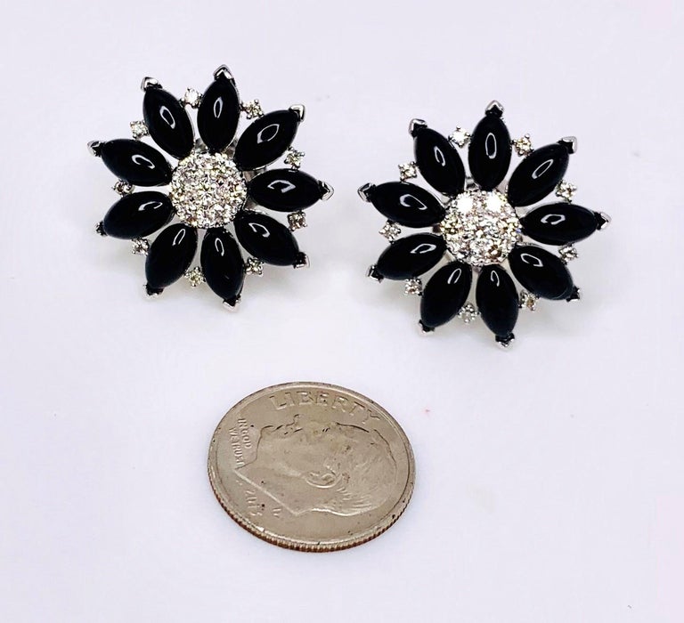 These diamond and black onyx floral earrings make a bold statement. Round brilliant-cut diamonds are set with marquise shaped black onyx cabochons in 18k white gold. The earrings have a modern, Art Deco look that is truly
