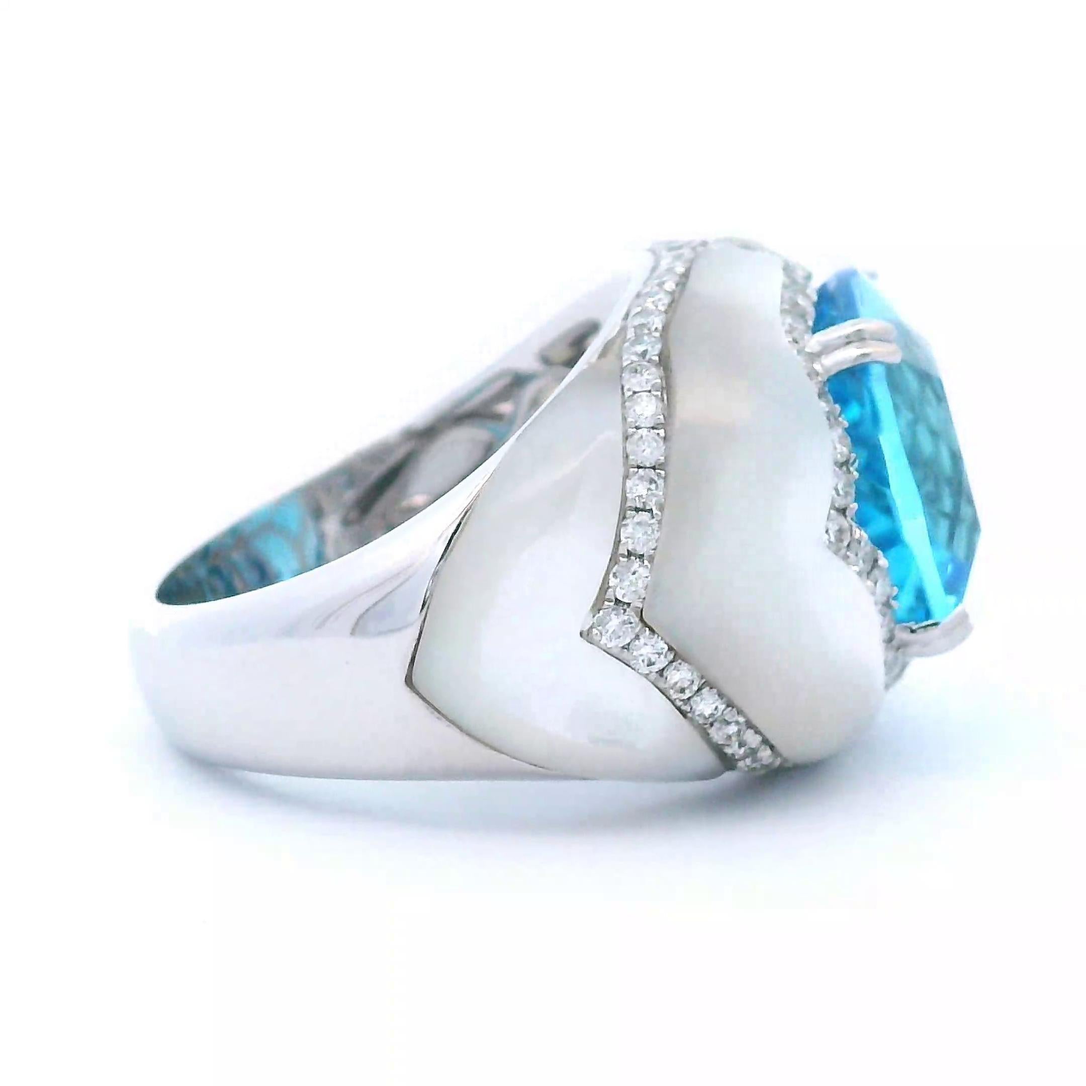 Atemberaubender Ring aus elektrischem Blautopas mit Perlmutt und Diamanten.
14.74 Karat Gesamtgewicht der Edelsteine.
Blauer Topas, 9,12 Karat, Kissen. 4 geschnitzte Perlmuttperlen, 4,99 Karat. 84 runde Brillanten, 0,63 Karat. Ungefähr Farbe G und