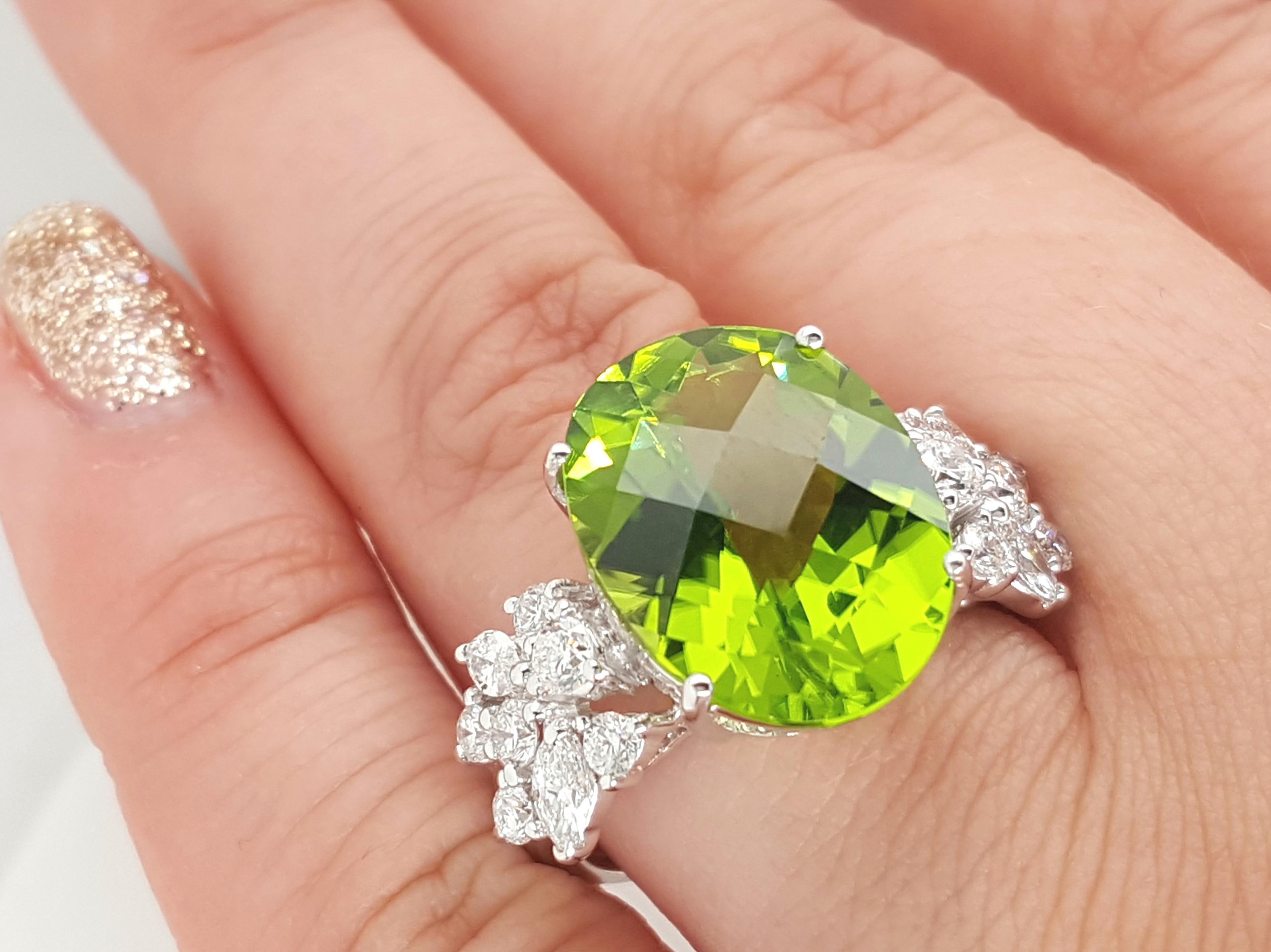 One Gorgeous 18K White gold natural peridot and diamond ring. The center is a 9.13CT natural oval bright green peridot with so much brilliance and life. The sides are adorned with illuminating marquise and round brilliant cut diamonds. Current size