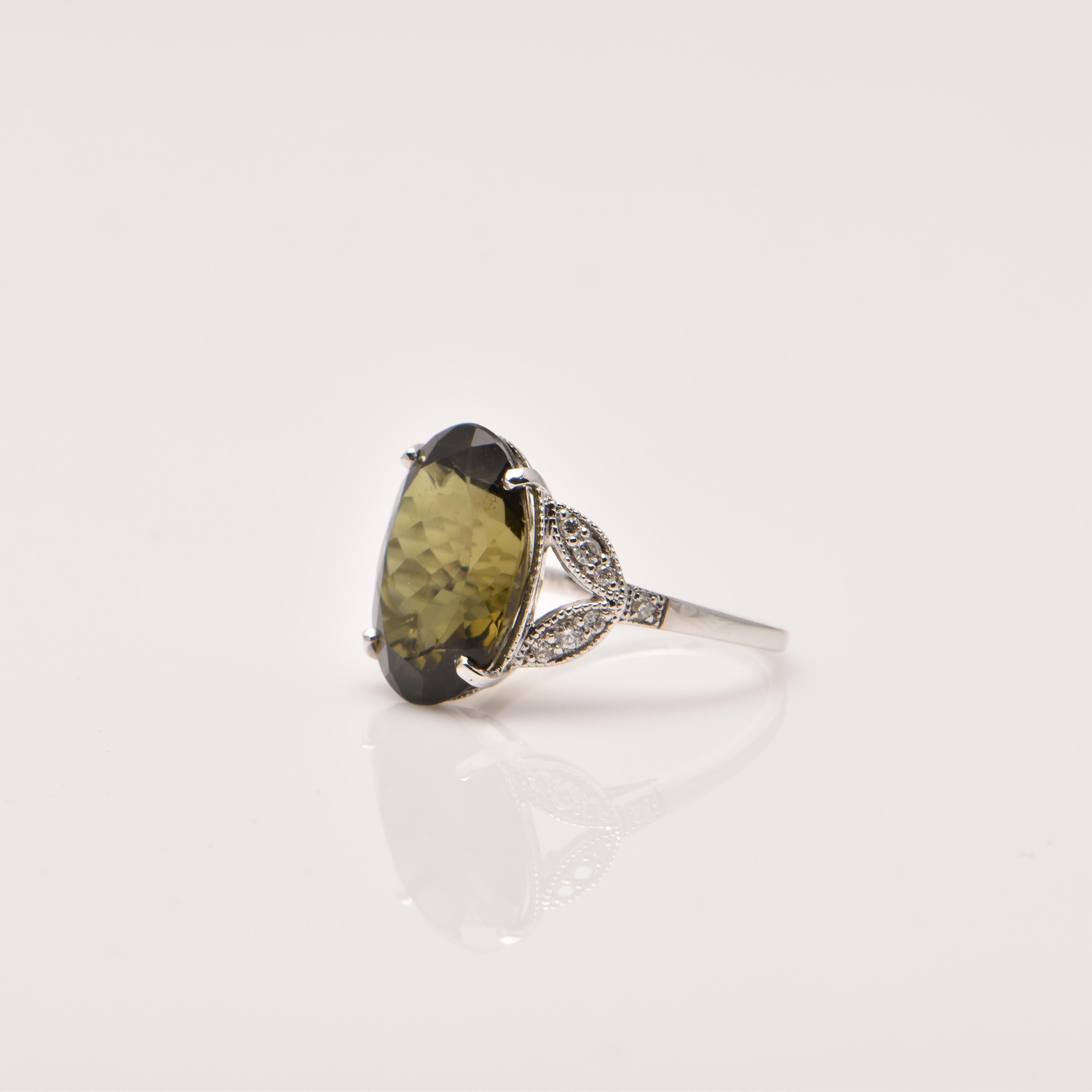 An 18ct White Gold ring showcasing a Green Tourmaline (9.13ct), and 14 Diamonds totalling 0.17ct.