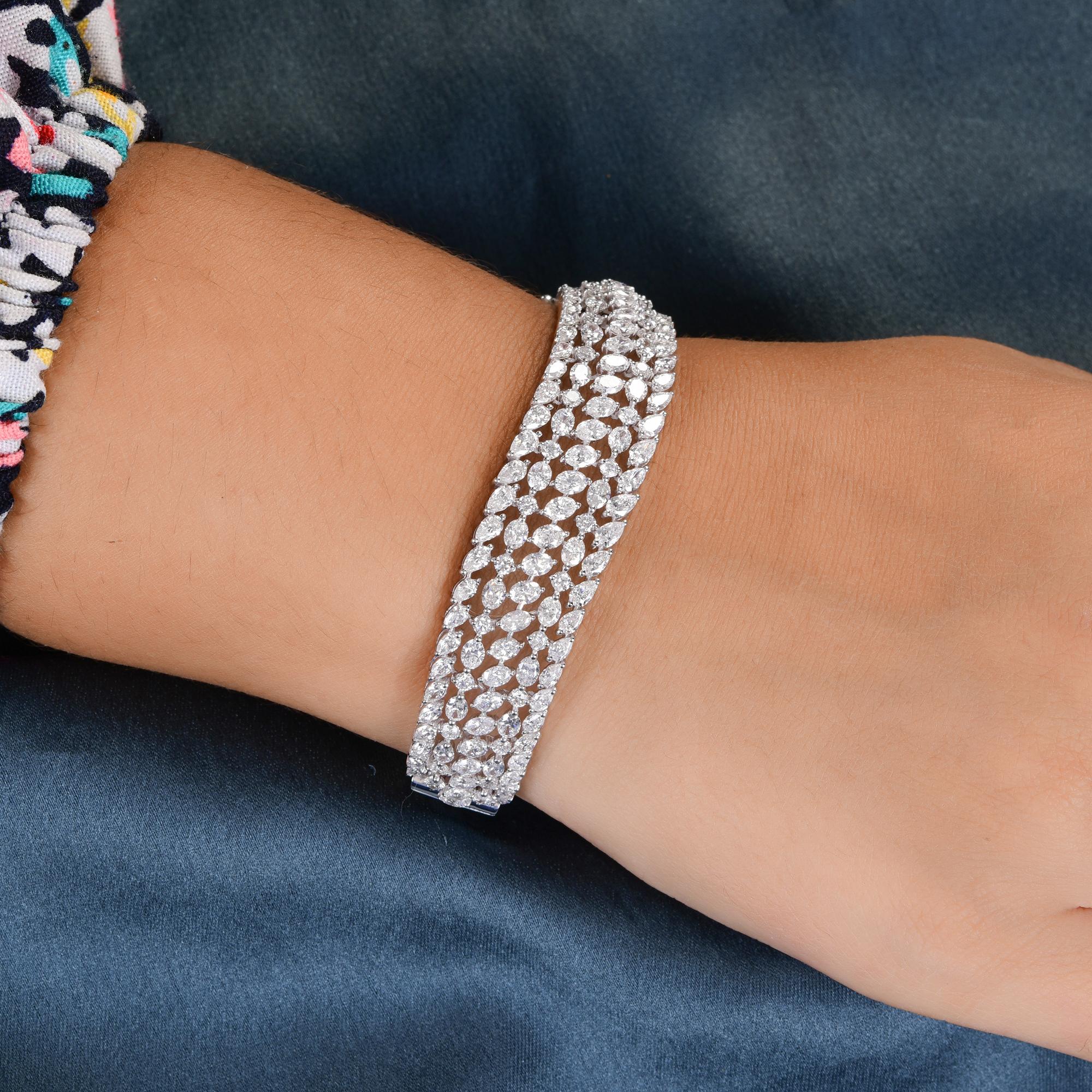 Este diamante de 9,2 quilates de claridad SI y color HI  La pulsera ancha de oro blanco de 18 quilates incluye diamantes de talla marquesa, redonda y pera engastados en varias filas, formando una pulsera ancha muy llamativa. 
Los diamantes son un