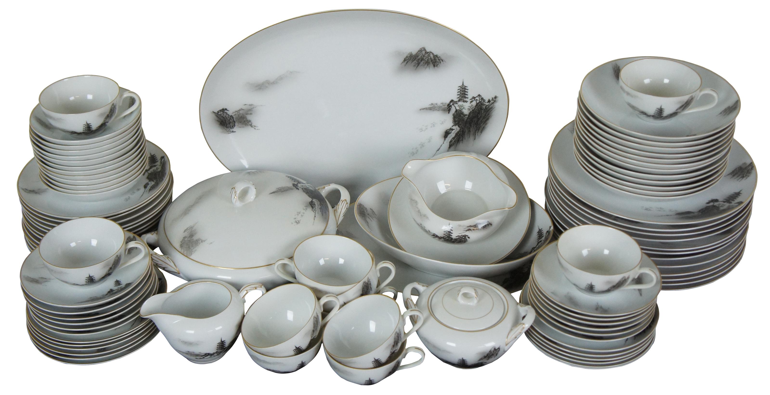 92 piece set of dinnerware by Fukagawa, pattern number 903, featuring a black and white pagoda tower on a rocky hillside or landscape with gilded edges.

Measures: Large Oval Platter - 16.5” x 12.25” x 1.5” / Small Oval Platter - 12.25” x 9.25” x