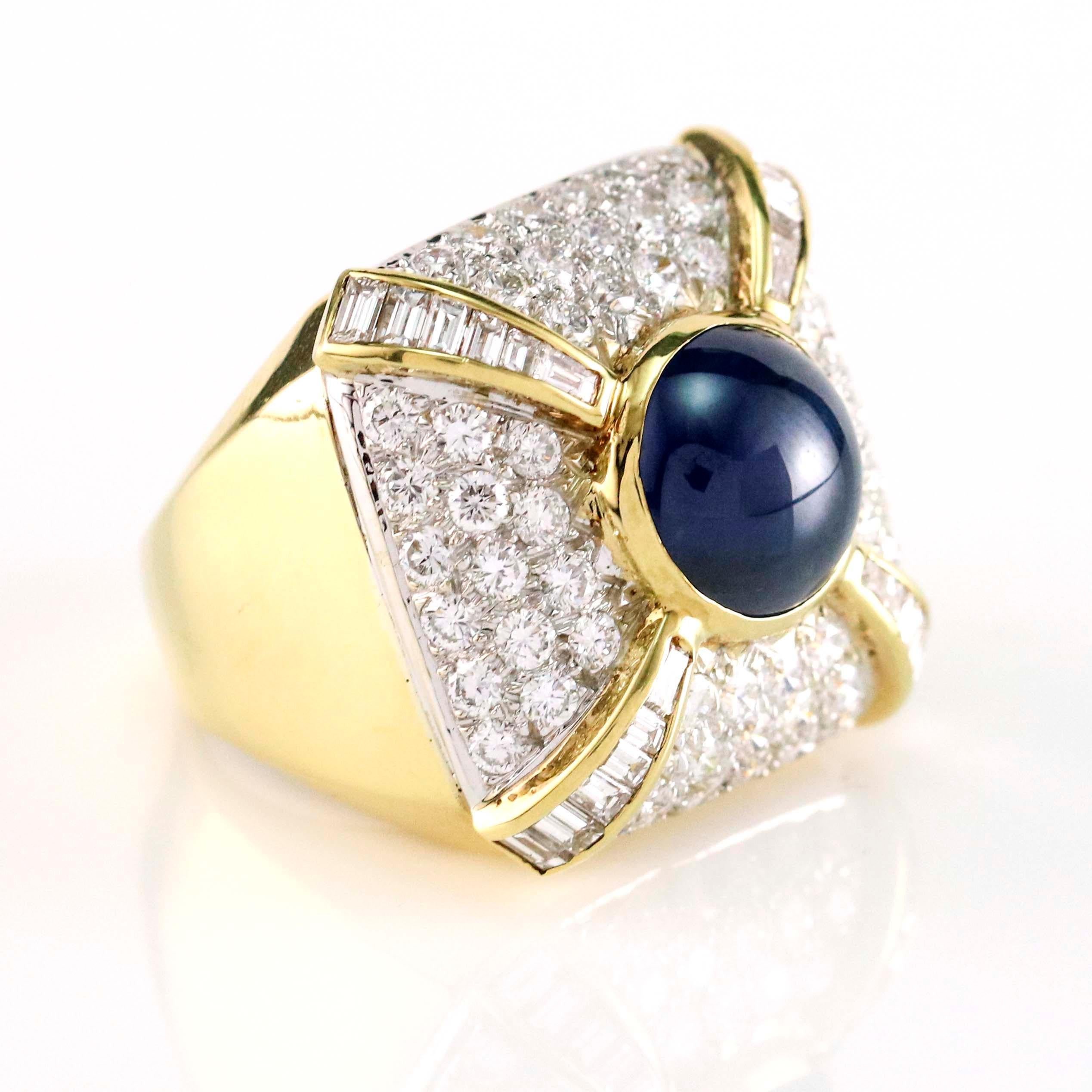 Sapphire and diamond square cocktail ring crafted in 14 karat yellow gold. Size 7. The ring is bead set with 60 full cut diamonds, channel set with 24 baguette cut diamonds, and bezel set with one cabochon cut natural blue sapphire. Total carat