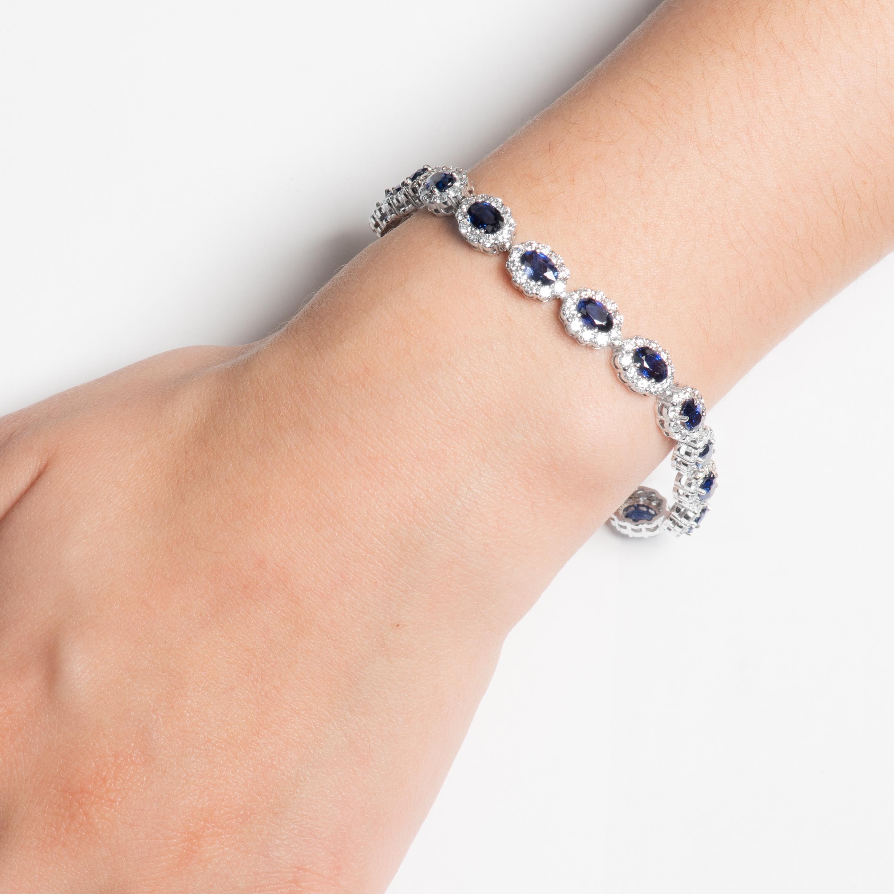 This stunning bracelet has 18 rich royal blue, well matched oval sapphires with a total weight of 9.21ct. They are surrounded by halos of round diamonds, with a total weight of 5.56ct. The bracelet itself is a 7 inch 14kt white gold bracelet.