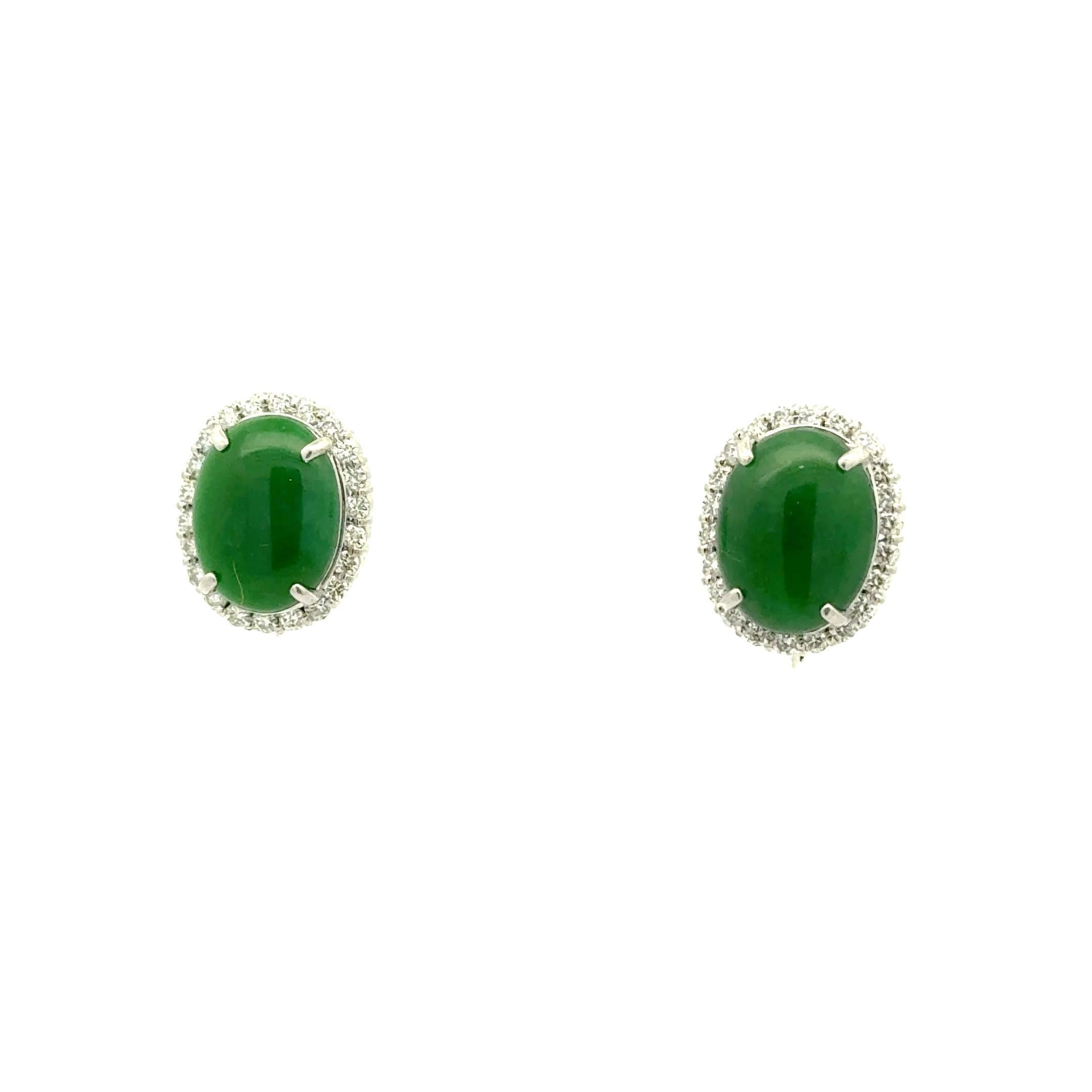 Une paire de boucles d'oreilles captivante avec des cabochons de jade de forme ovale, pesant 9,23 carats. Les pierres de jade présentent une riche teinte verte, dégageant élégance et profondeur. Chaque jade est entouré d'un halo de diamants blancs