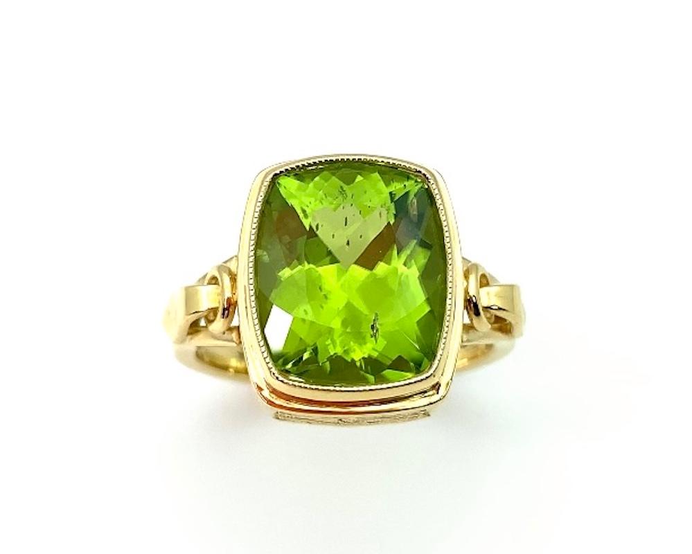 It's so easy being green! Wear this brilliant, absinthe colored peridot with anything. This ring features a large, fine quality, cushion cut peridot, bezel set in an exquisitely hand-engraved ring with classical details. The level of craftsmanship