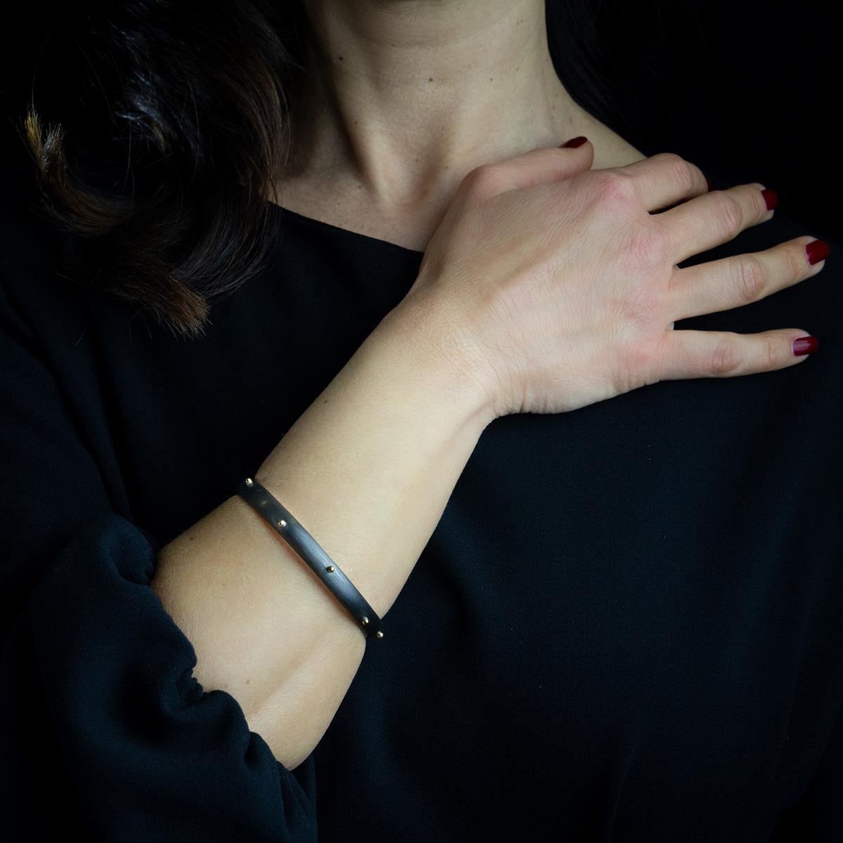 Bracelet handmade by our Italian goldsmith masters in gray burnished 925 silver and 18 kt yellow gold. 
If gold and silver make women feel precious, burnished jewels are the trendy detail that characterizes a precise style and a way of being. 
This