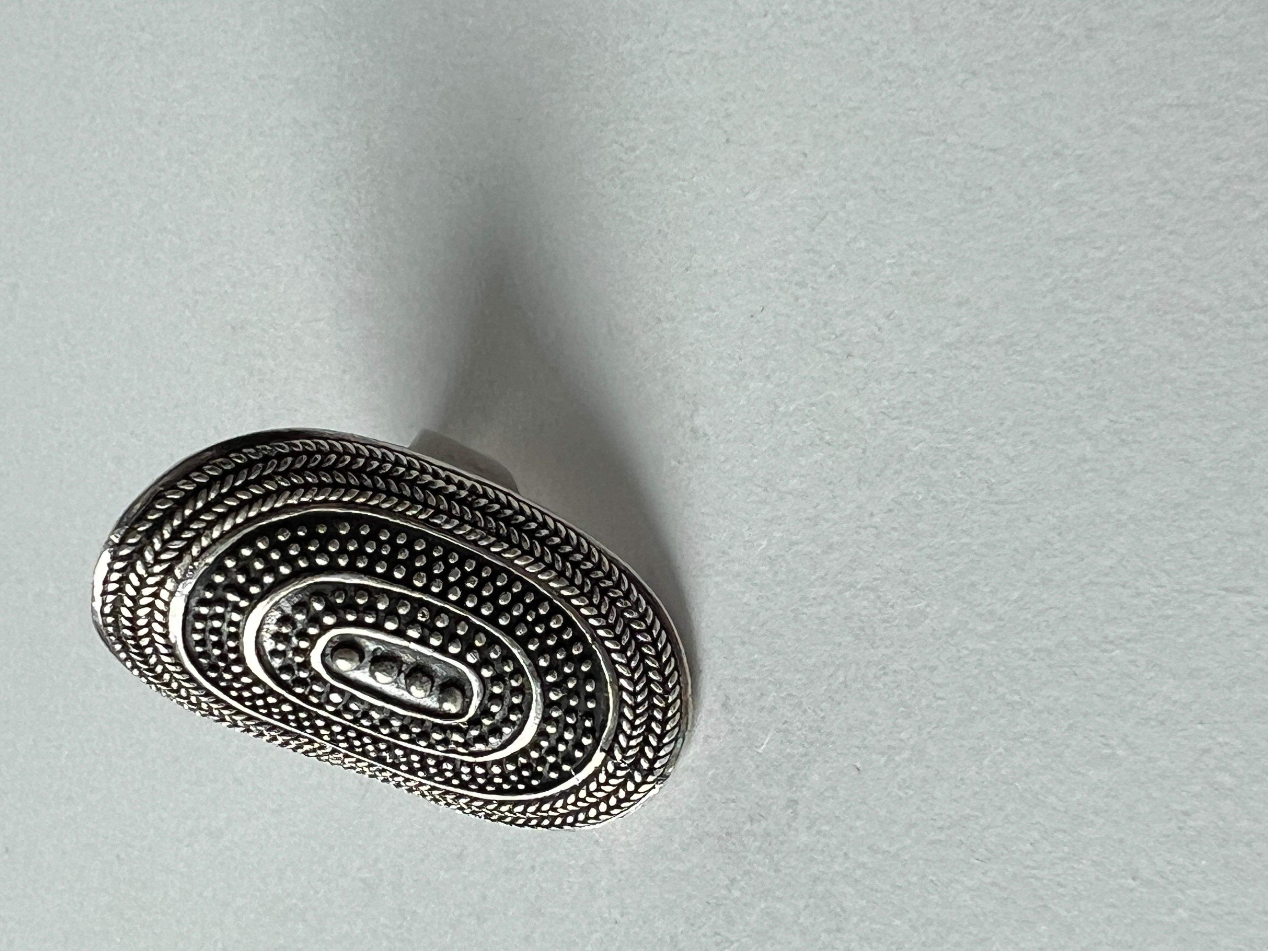 Vintage ring with an intricate design featuring an oval disc with a caviar texture. Solid feel, sophisticated and unique. 

Weight: 0.48 oz (13.6 grams)
Size: 9.5 
Condition: vintage, with minimal signs of wear (see pictures)
Stamped with 925.

***