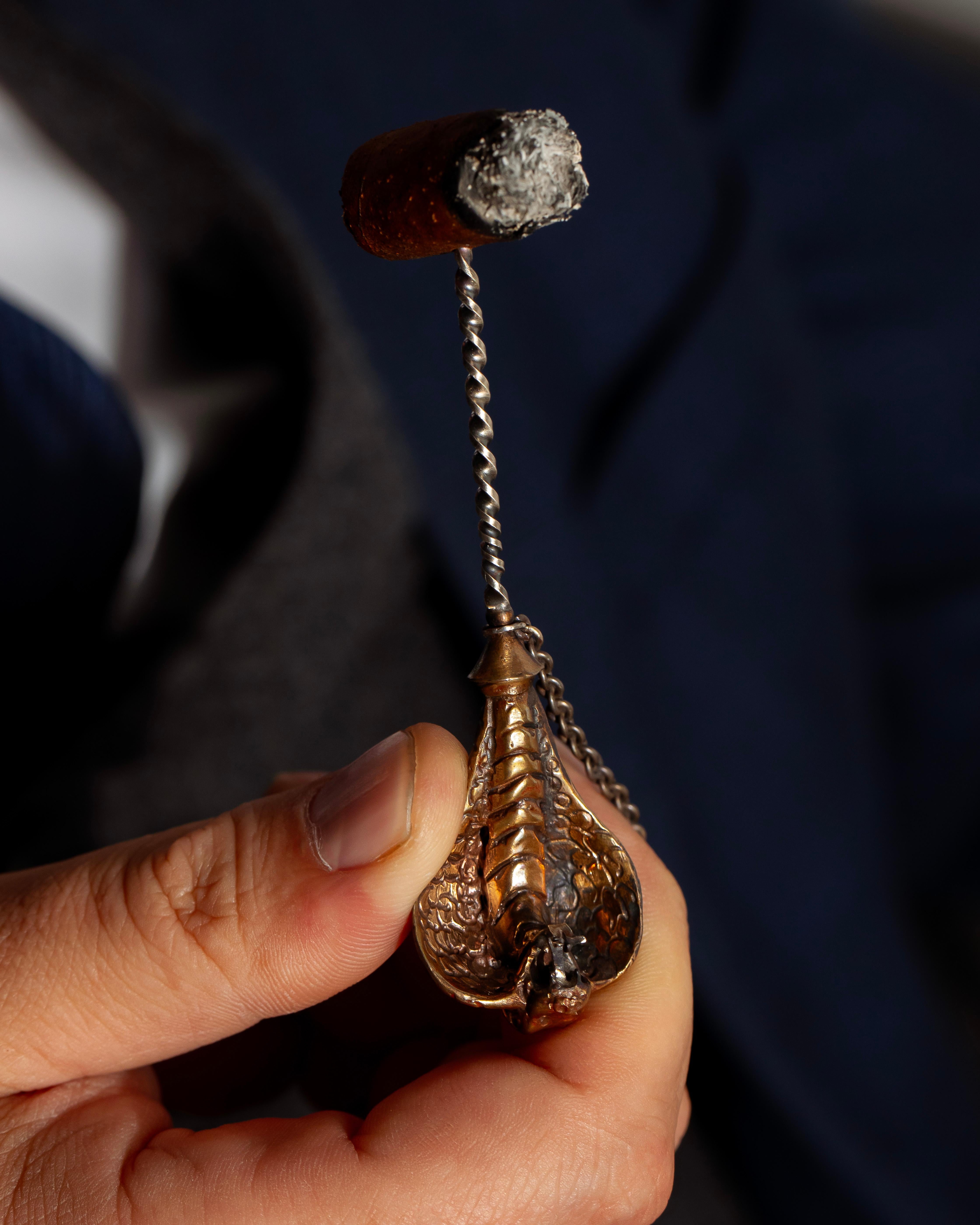 Remarquable et symbolique, ce perce-cigare artisanal présente une tête de cobra sculpturale, magistralement coulée dans le bronze. Le cobra, symbole de puissance, de transformation et de sagesse, confère à cet objet une aura mystique qui en fait un