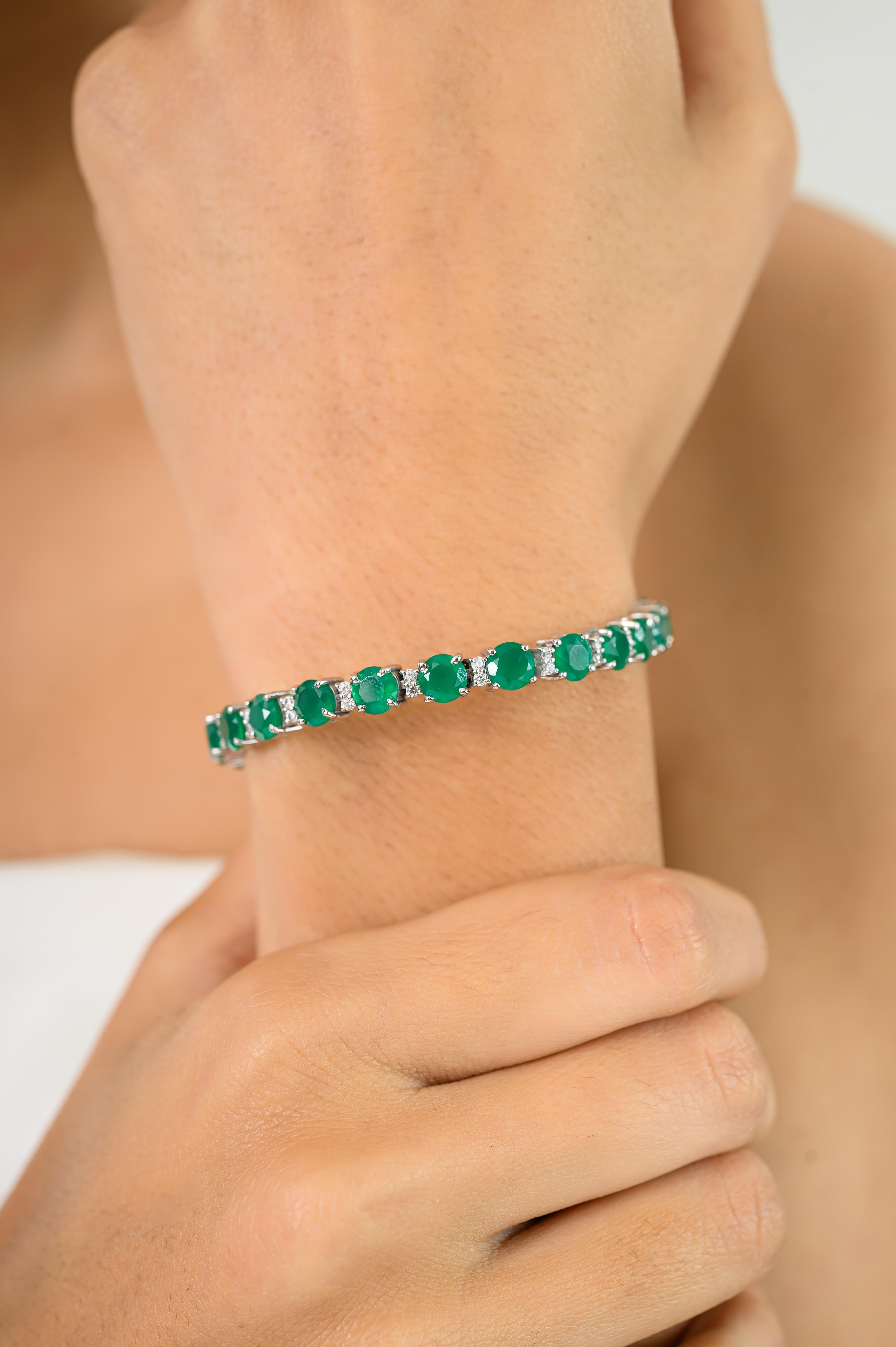 Dieses Smaragd- und CZ-Tennisarmband im Contemporary Style ist ein auffälliges Tennisarmband aus 925er Sterlingsilber. Mit lebhaften Smaragdsteinen im Rundschliff, die von schimmernden Zirkonia akzentuiert werden, bietet dieses Schmuckstück ein
