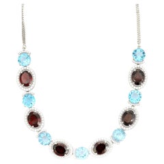 Collar de plata 925 con granate y topacio azul en dos tonos y halo de circonitas cúbicas