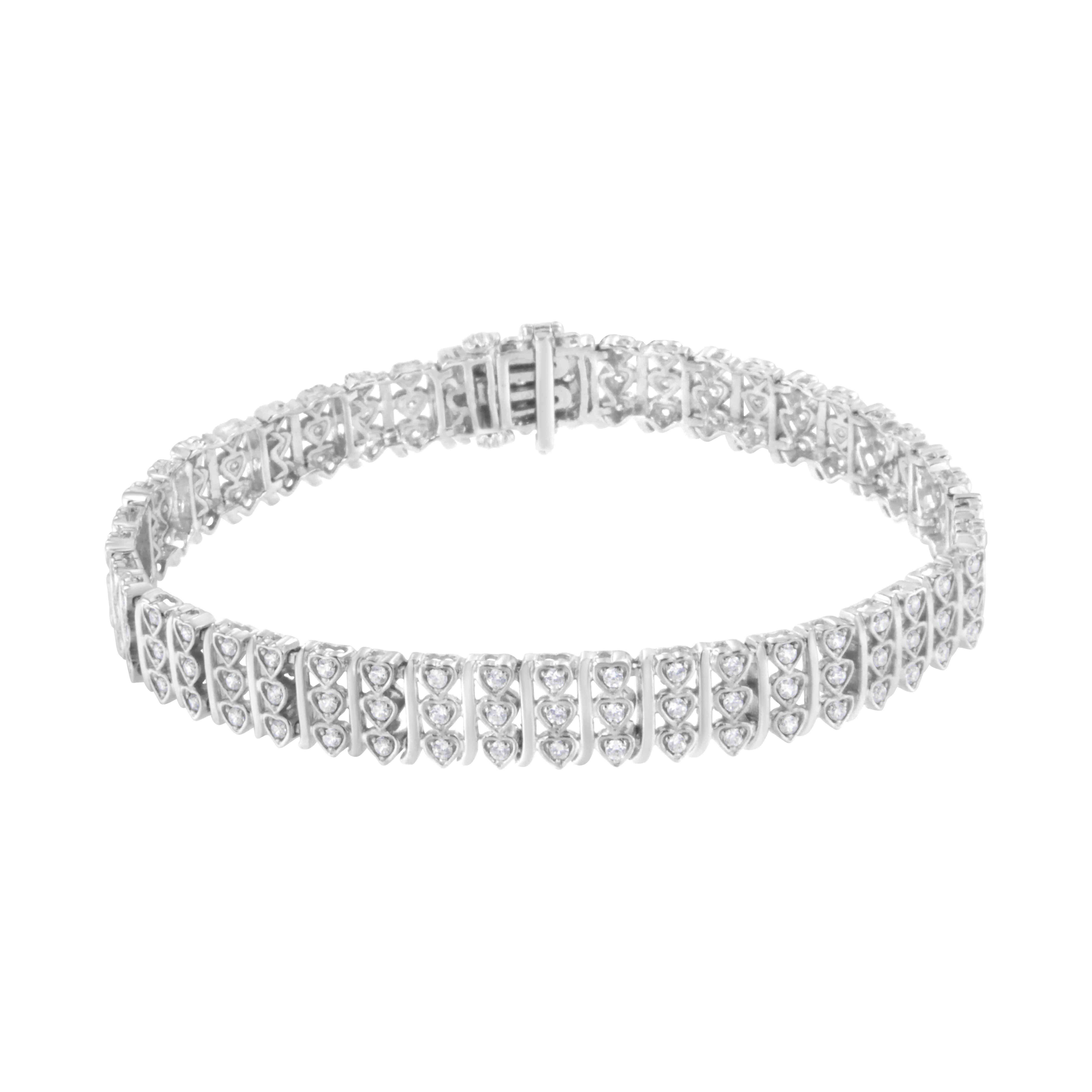 This lovely sterling silver bracelet features 1 1/2 carats of beautiful, natural diamonds. The design of this piece features a repetitive pattern of vertical rows of 3 silver hearts, each embellished with a round-cut diamond, separated by a subtle