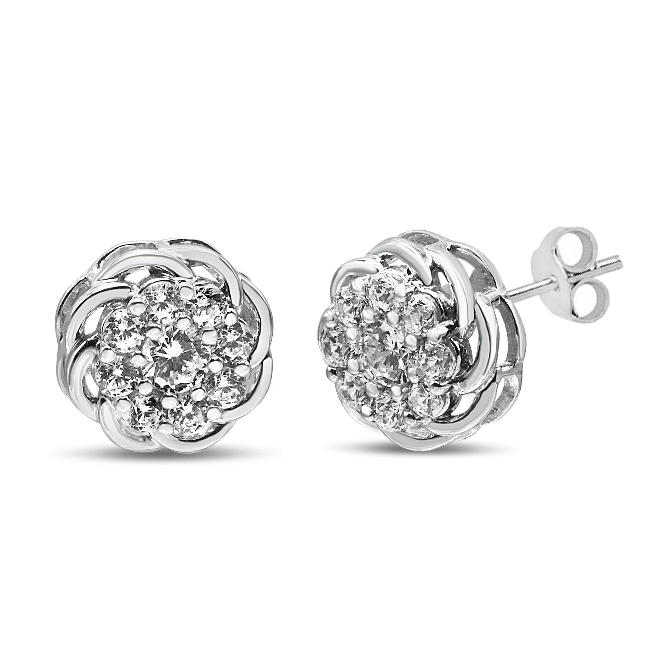 Clusters of brilliant round diamonds nestled within prong settings adorn this pair of openwork floral stud earrings for shimmering splendor. Polished .925 sterling silver is a sophisticated partner to these sparkling diamonds that total 1/2 cttw