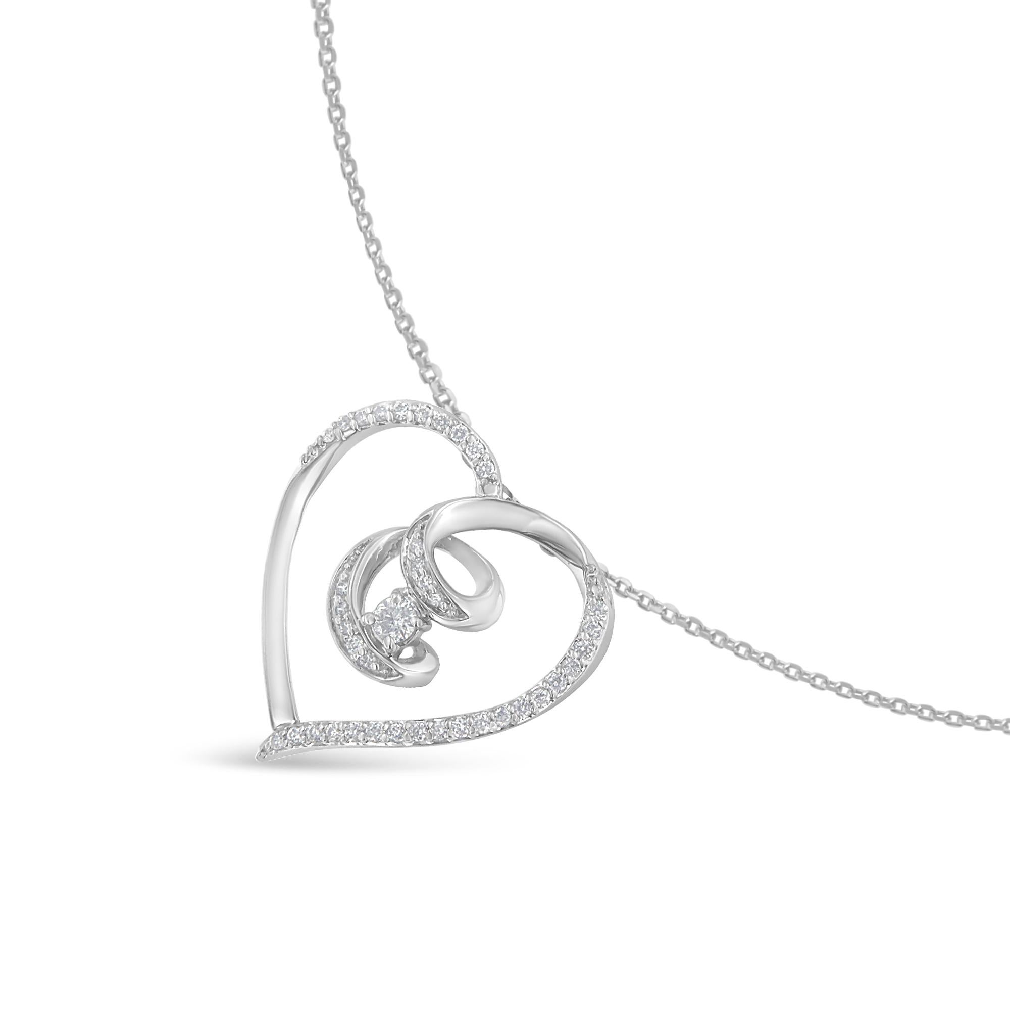 A .925 sterling silver ribbon flows to create a delicate heart shape that finishes off with a swirl that drops halfway down the middle of the heart. Scattered throughout the ribbon heart 1/4ct TDW of round cut diamonds sparkle. Held within the