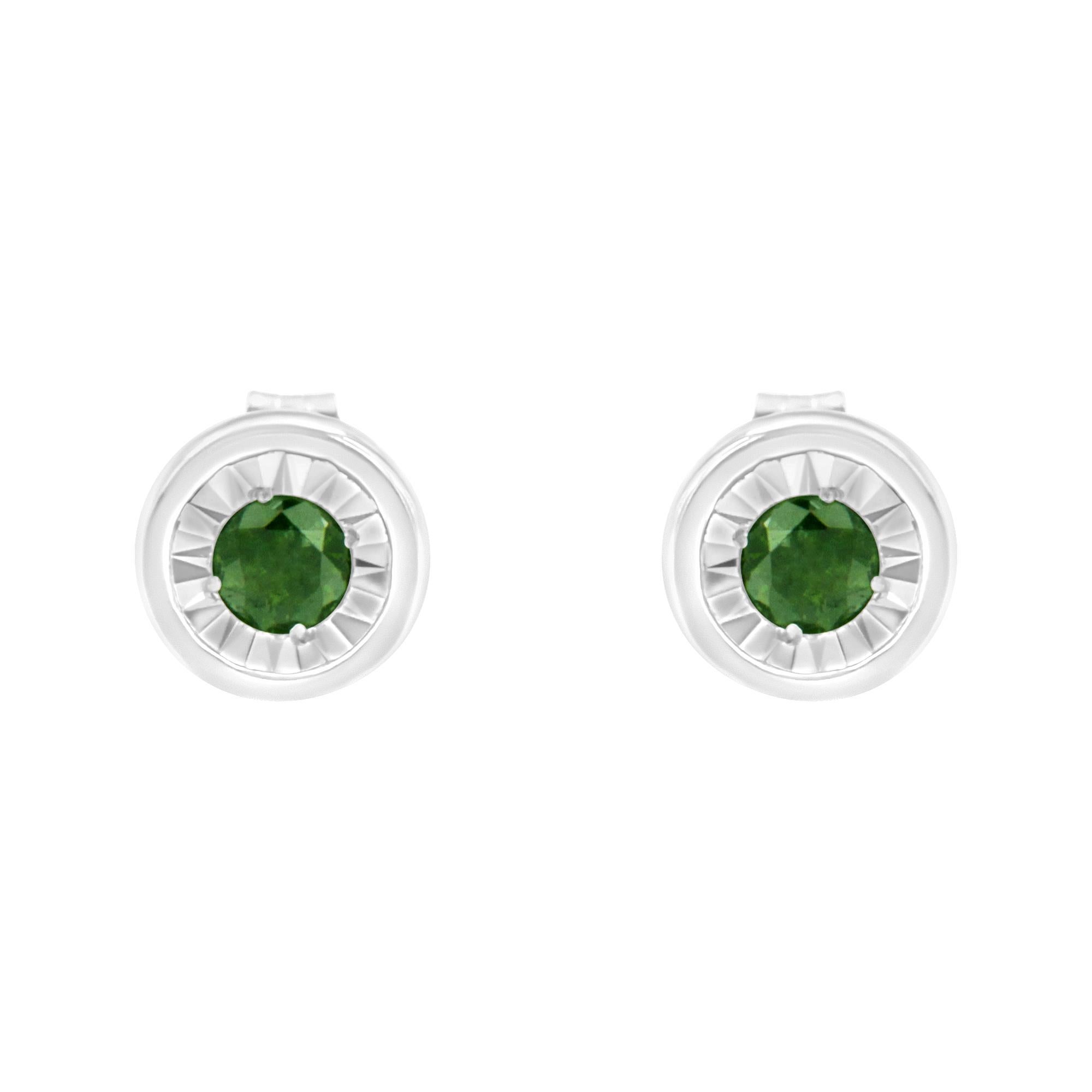 This sleek pair of diamond studs features color treated green diamonds in a bezel setting. The modern design is crafted in a cool sterling silver making them the perfect choice to add a touch of color to everyday wear. The total diamond weight is