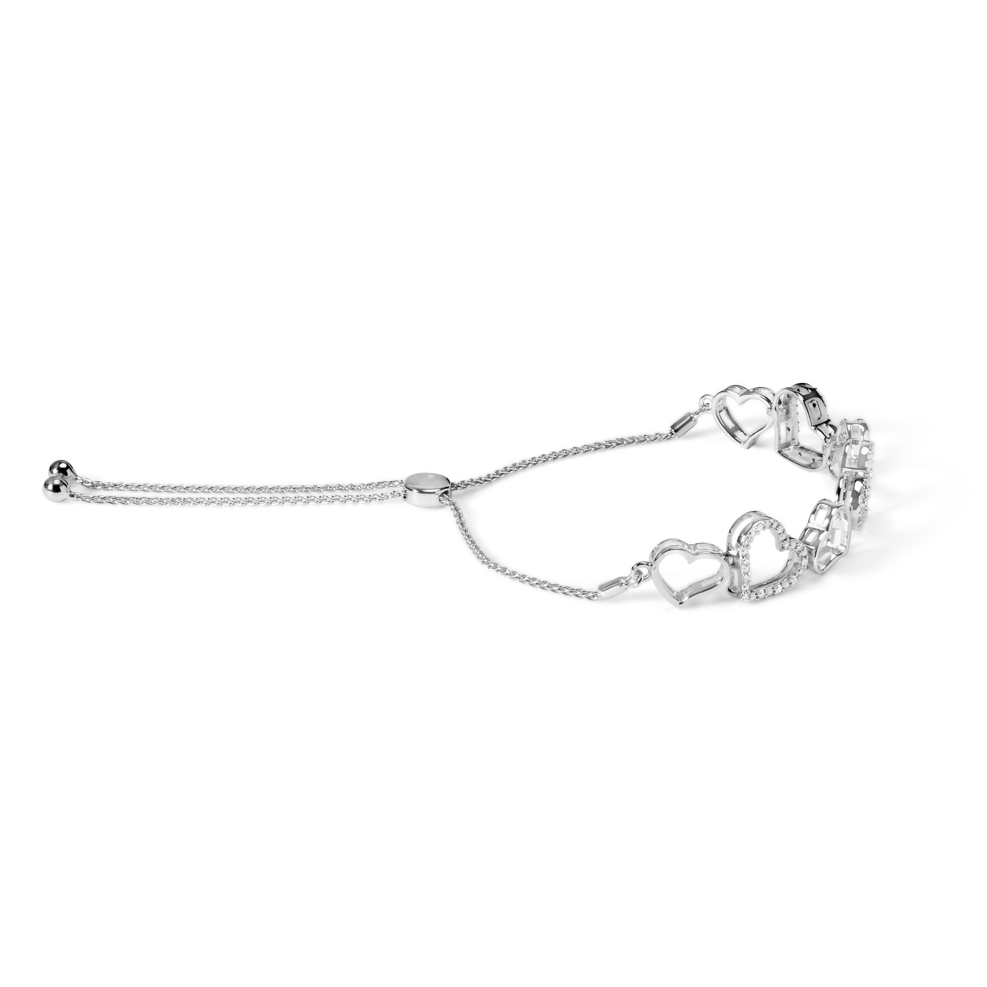 Exquisément confectionné, ce bracelet en argent 925, rhodié pour plus de brillance, incarne l'élégance avec ses cœurs ouverts qui s'entrecroisent. Orné de diamants naturels, chaque cœur brille avec une pureté de I2-I3 et des teintes de I-J, captant
