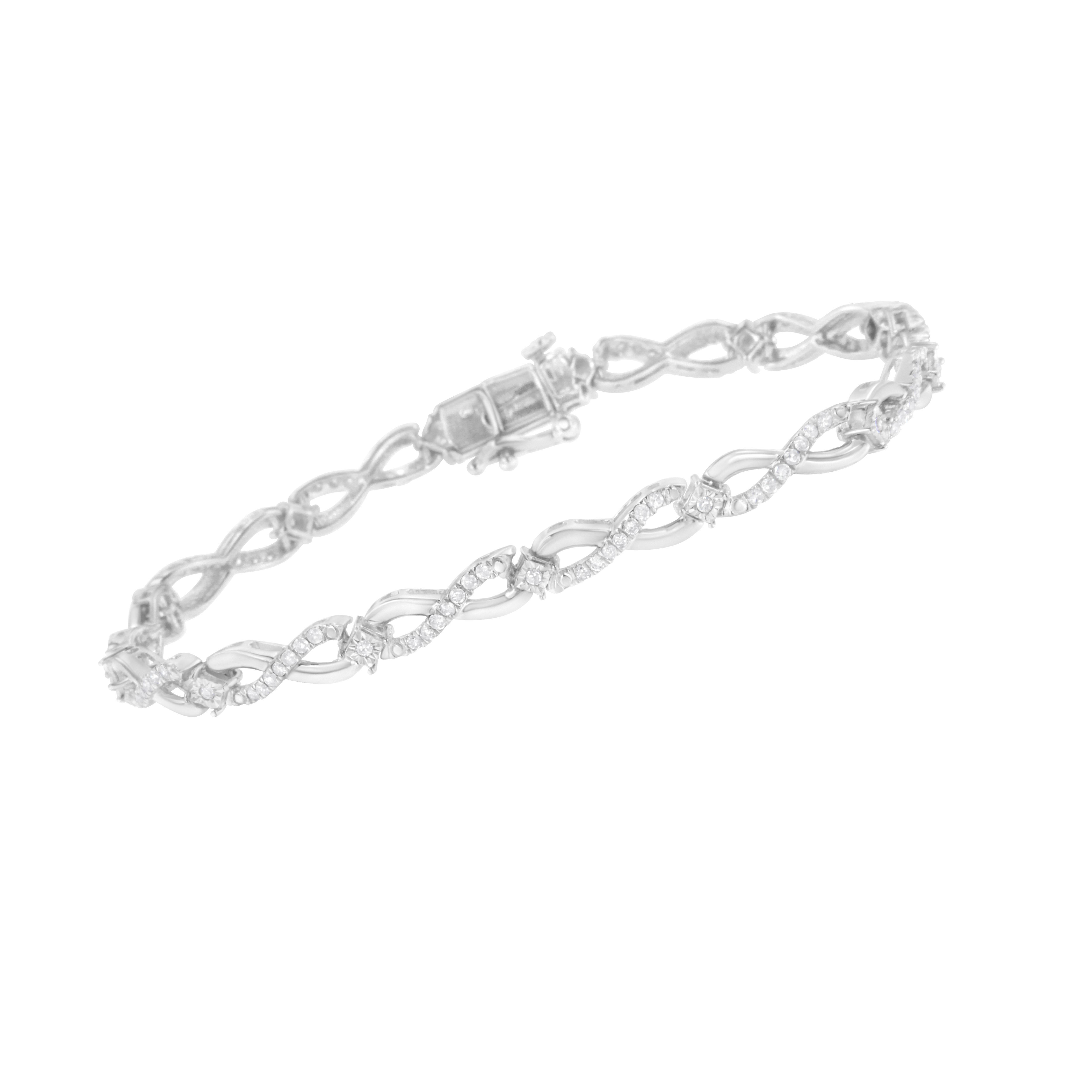 A hundred and three round cut diamonds weighing 1 ct TDW dazzle in this sterling silver bracelet. Soft ribbons loop around and create an infinity symbol. Twinkling round cut diamonds inlay one of the sides of the symbol. Individually set round cut
