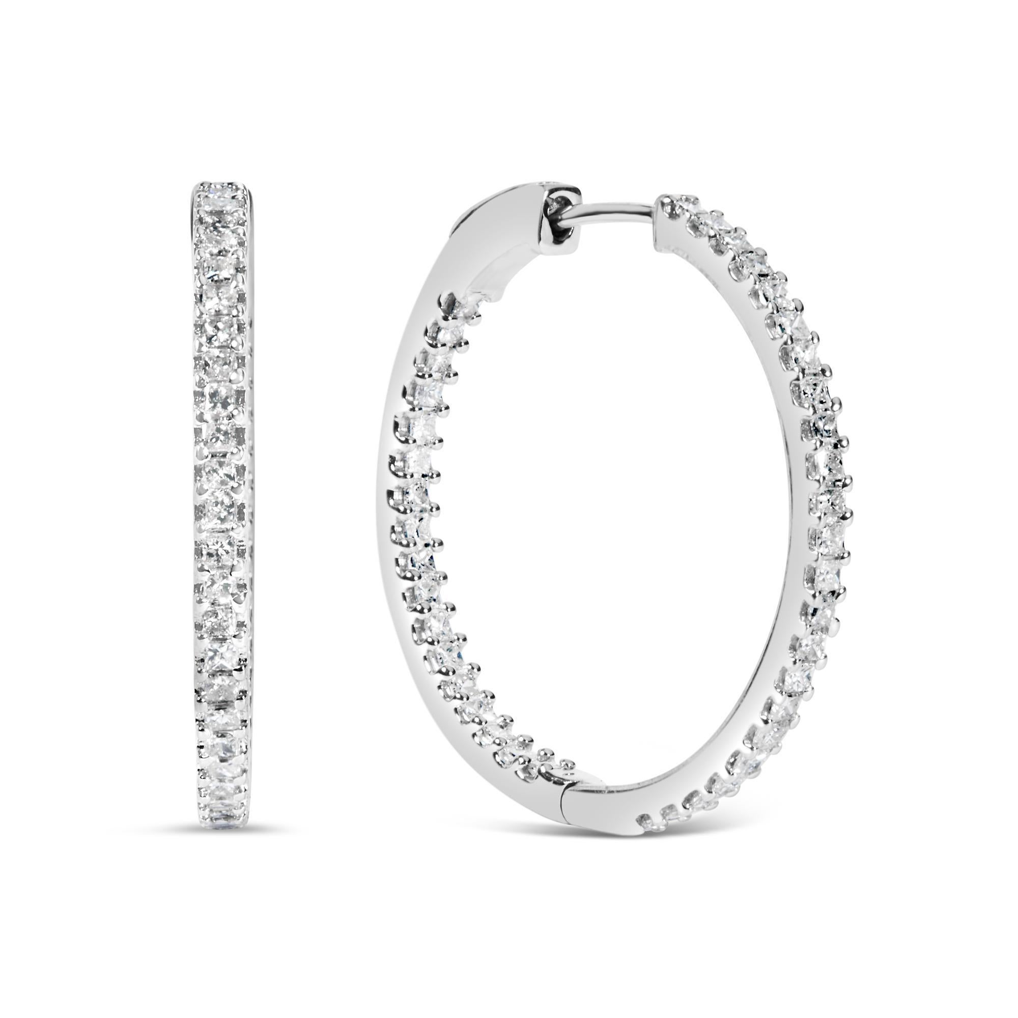 Eleganza senza tempo con questi orecchini a cerchio in argento sterling 925 placcato rodio, che misurano 23 mm di diametro ciascuno. Realizzati con precisione meticolosa, sono impreziositi da incantevoli diamanti naturali con taglio princess per un