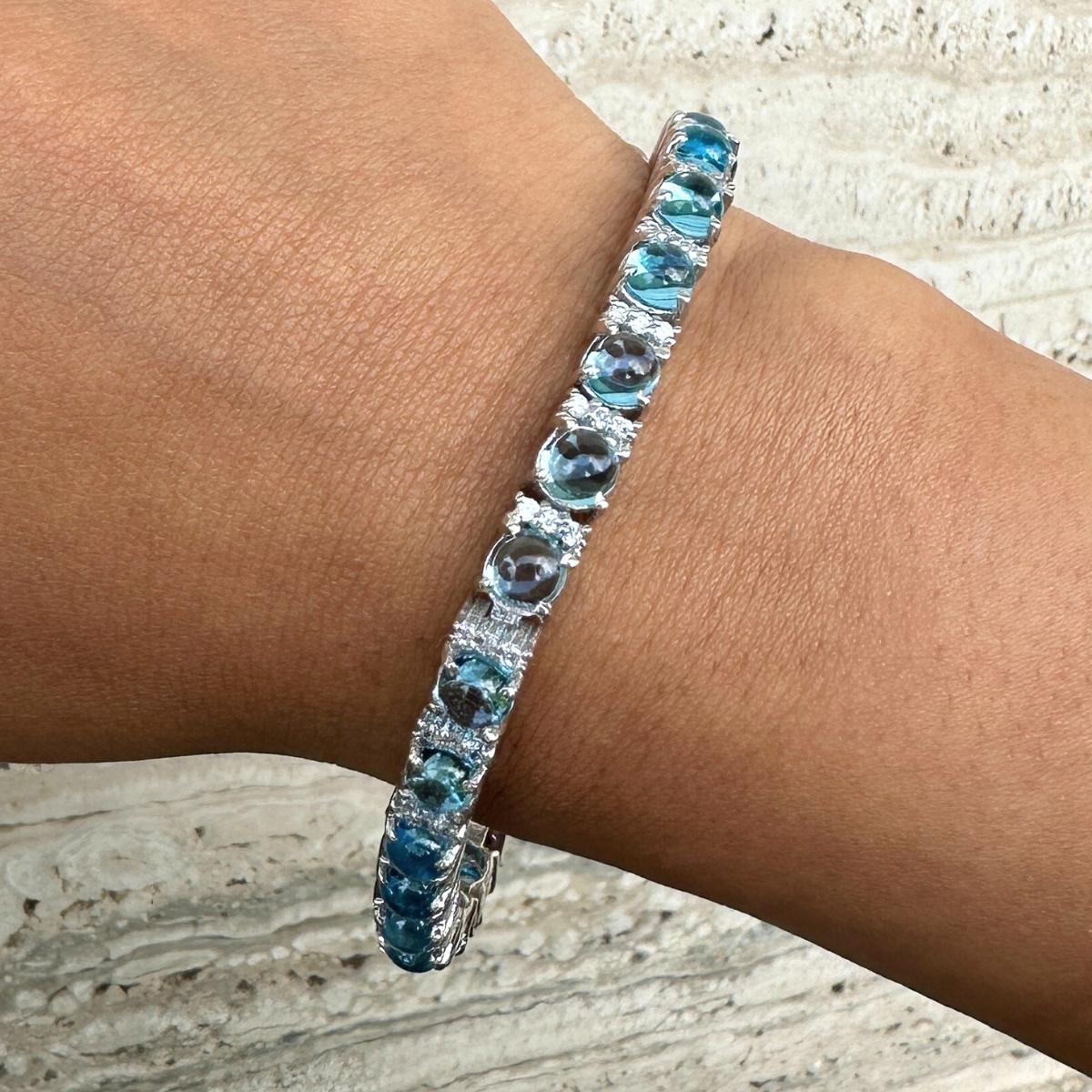 14.49 Carat Blue Topaz and Diamond Tennis Bracelet in sterling silver showcases endlessly sparkling natural blue topaz, weighing 14.49 carat. It measures 7 inches long in length. 
Blue Topaz stimulate concentration and reduces stress. 
Designed with
