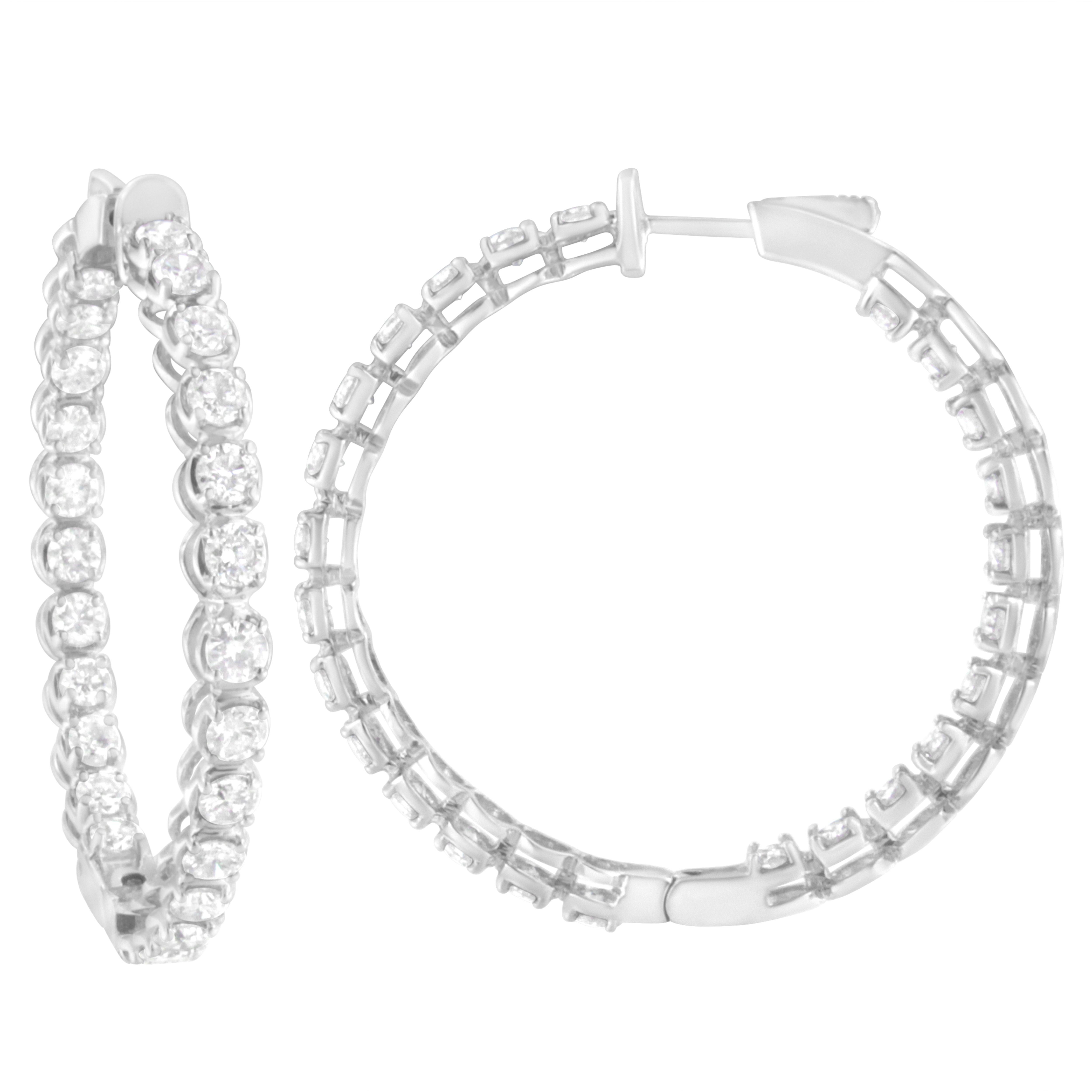 A classic statement hoop earring with a unique inside-out diamond design set in the finest .925 sterling silver. This gorgeous piece has 50 natural, round-cut diamonds in a prong setting for a total of 7 ct. These natural diamonds are color rated as