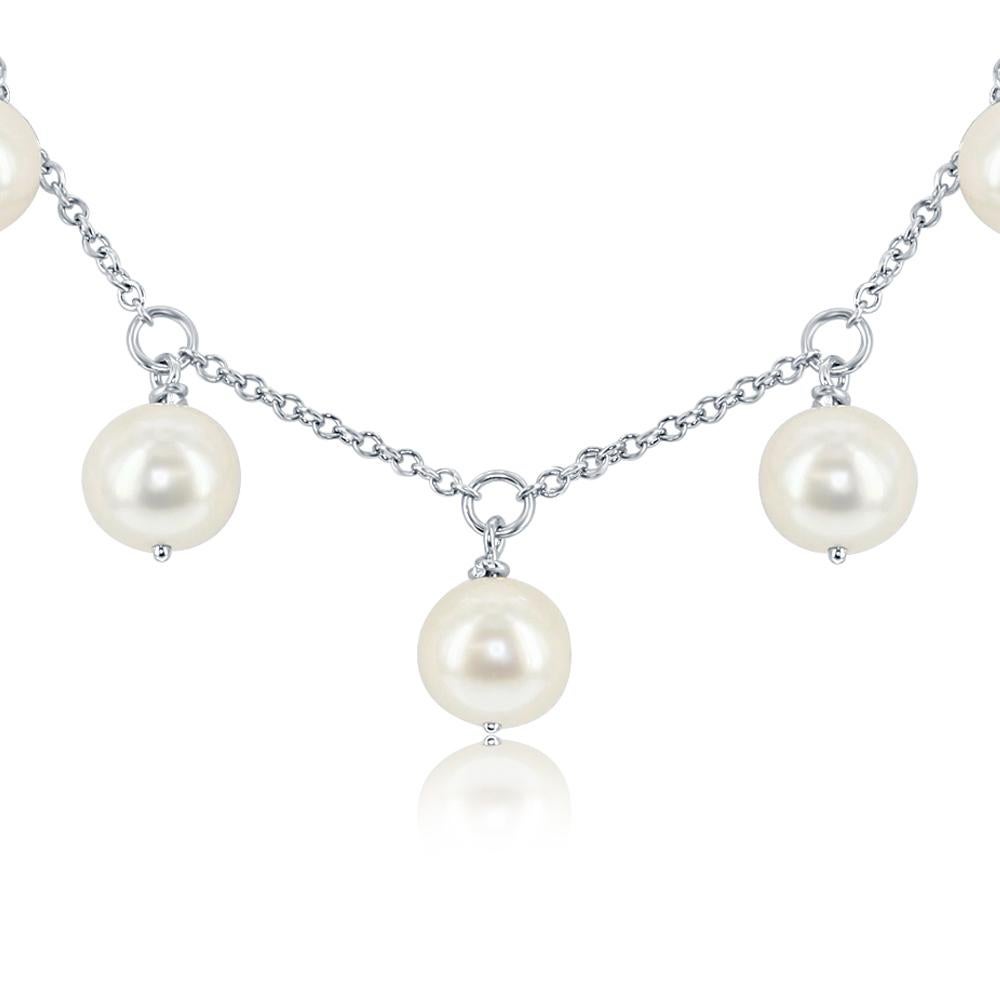 This Chinese freshwater necklace features nine white, round 7mm pearls dangling from a sterling silver chain. The necklace can be worn as a standalone piece, or stacked with others. This contemporary look will immediately become a staple of your