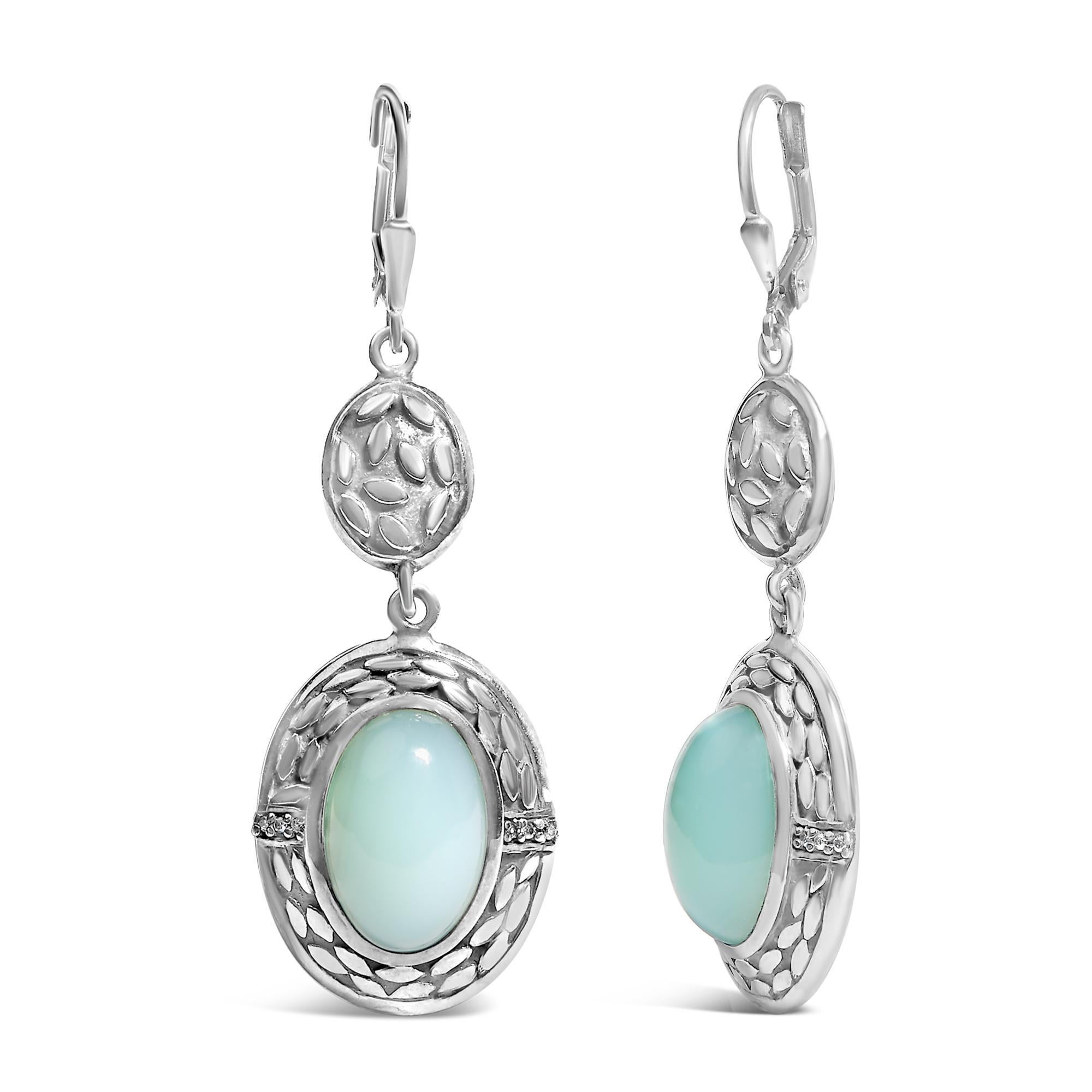 Entwine elegance and a whisper of enchantment on your ears with these stunning drop and dangle earrings, masterfully crafted from rhodium-plated .925 sterling silver. Each earring cradles a large, oval-cut Chalcedony, natural in origin and