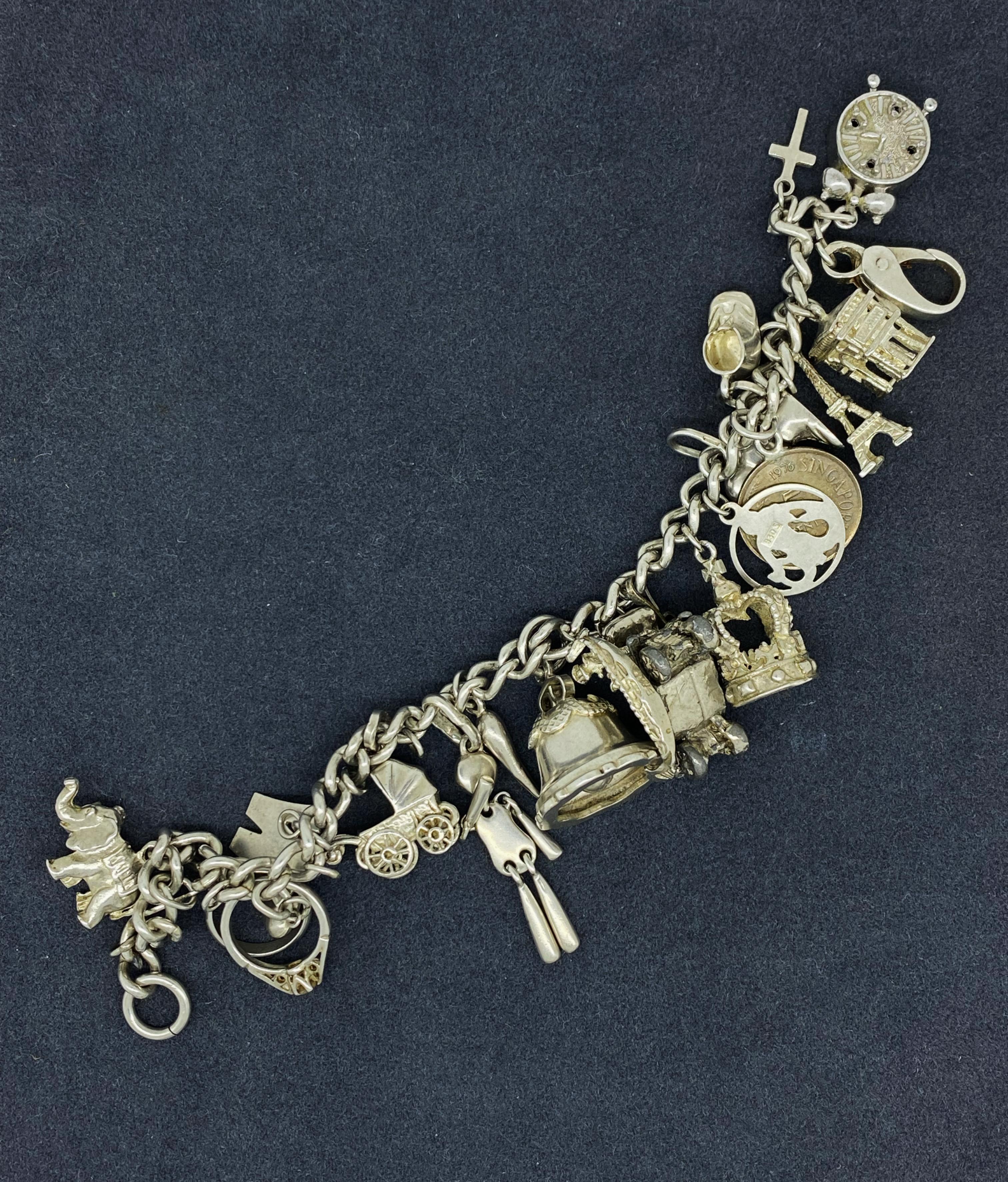Questo magnifico braccialetto di charme è realizzato in argento Sterling 925,
con 20 charme (17 dei quali in argento e 3 in metallo):

Sveglia, Croce, Arco di Trionfo, Torre Eiffel, 
Moneta di Singapore da 5c, Scarpe, Cuore, Segno zodiacale