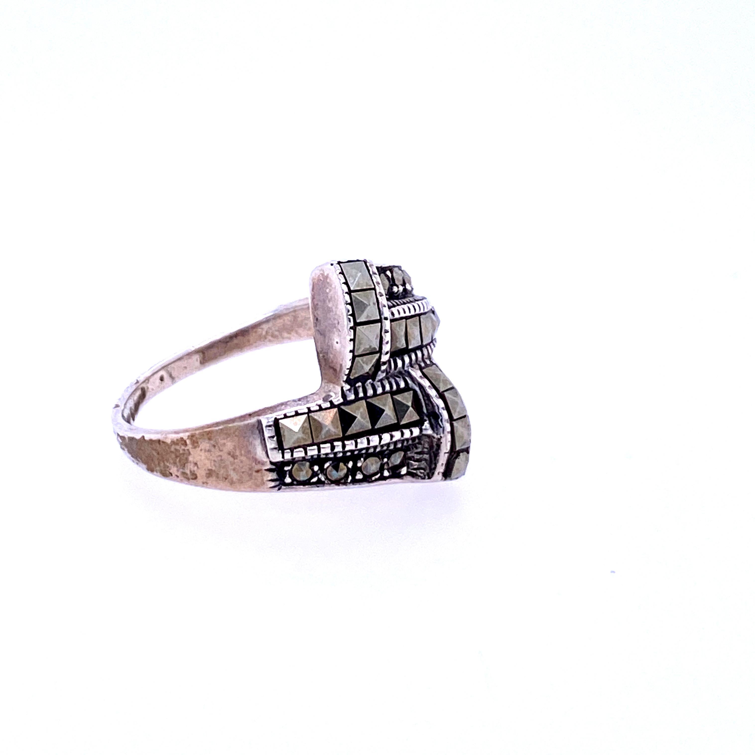 One sterling silver (stamped 925) ring set with eighteen square marcasites and eight round marcasites.  The shank measures 17.2mm near the top of the ring and tapers to 1.9mm at the base.  The ring is a finger size 7.75.