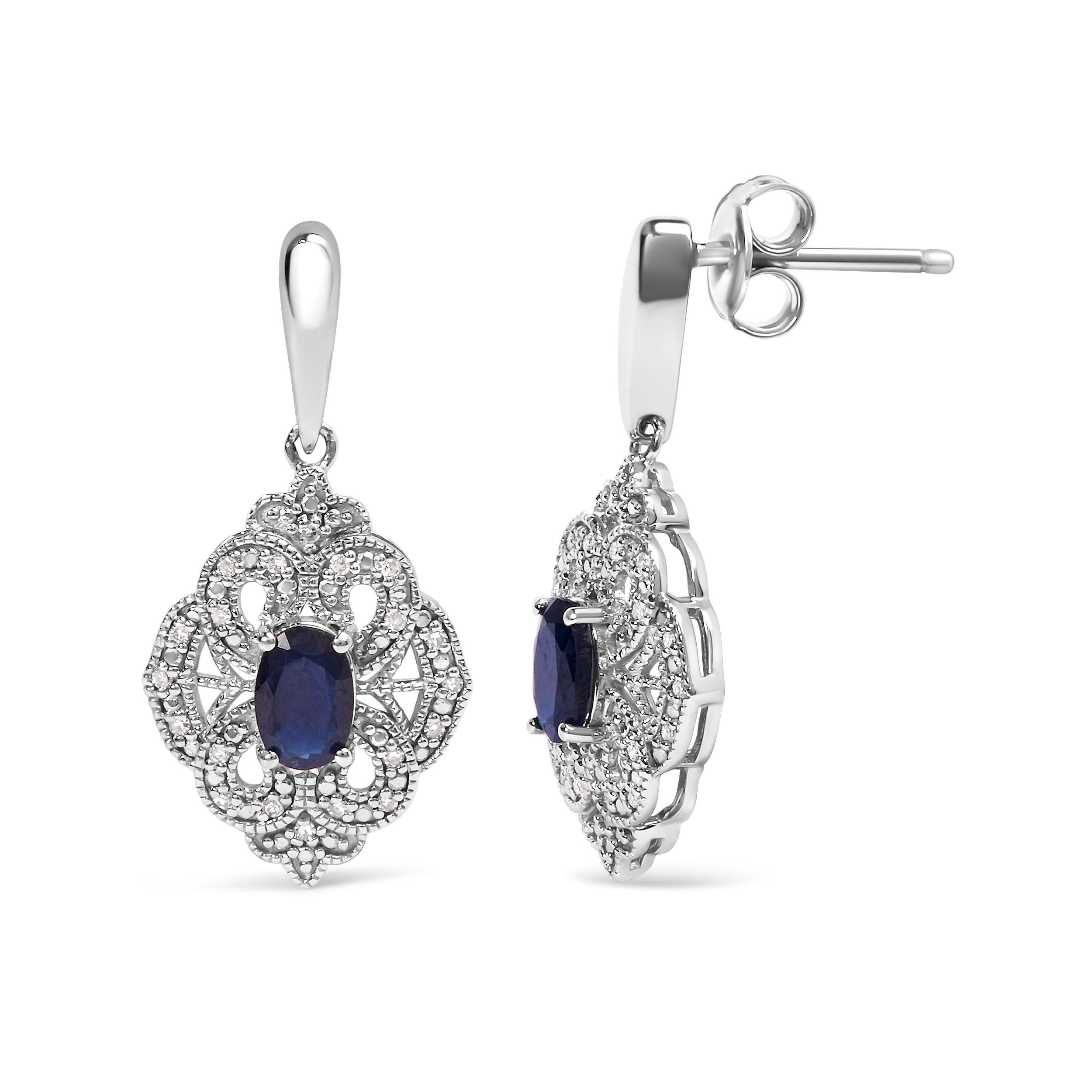 Embark on a journey of timeless elegance with these exquisite Art Deco-inspired shield dangle earrings. Crafted from the finest .925 sterling silver, they showcase the harmonious interplay of natural diamonds and lab-created blue sapphires. The