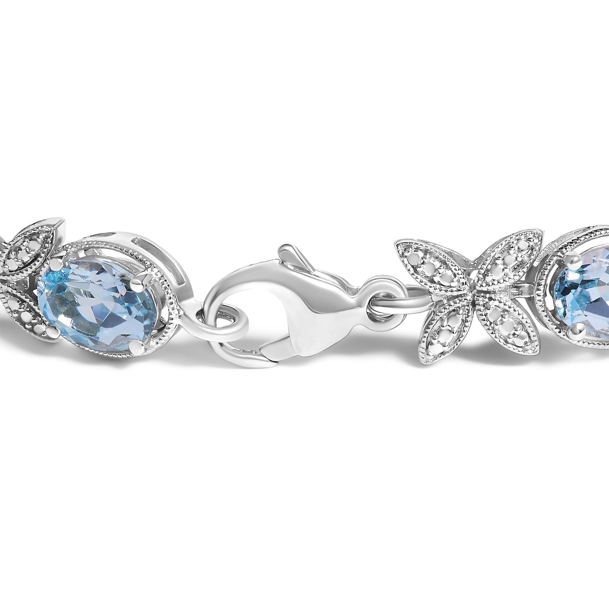 Dieses bezaubernde Armband aus rhodiniertem 925er Sterlingsilber schmückt Ihr Handgelenk mit der heiteren Schönheit eines natürlichen Blautopas in Ost-West-Ausrichtung, wobei jeder Stein eine ruhige Weite von wasserfarbener Pracht darstellt. Obwohl