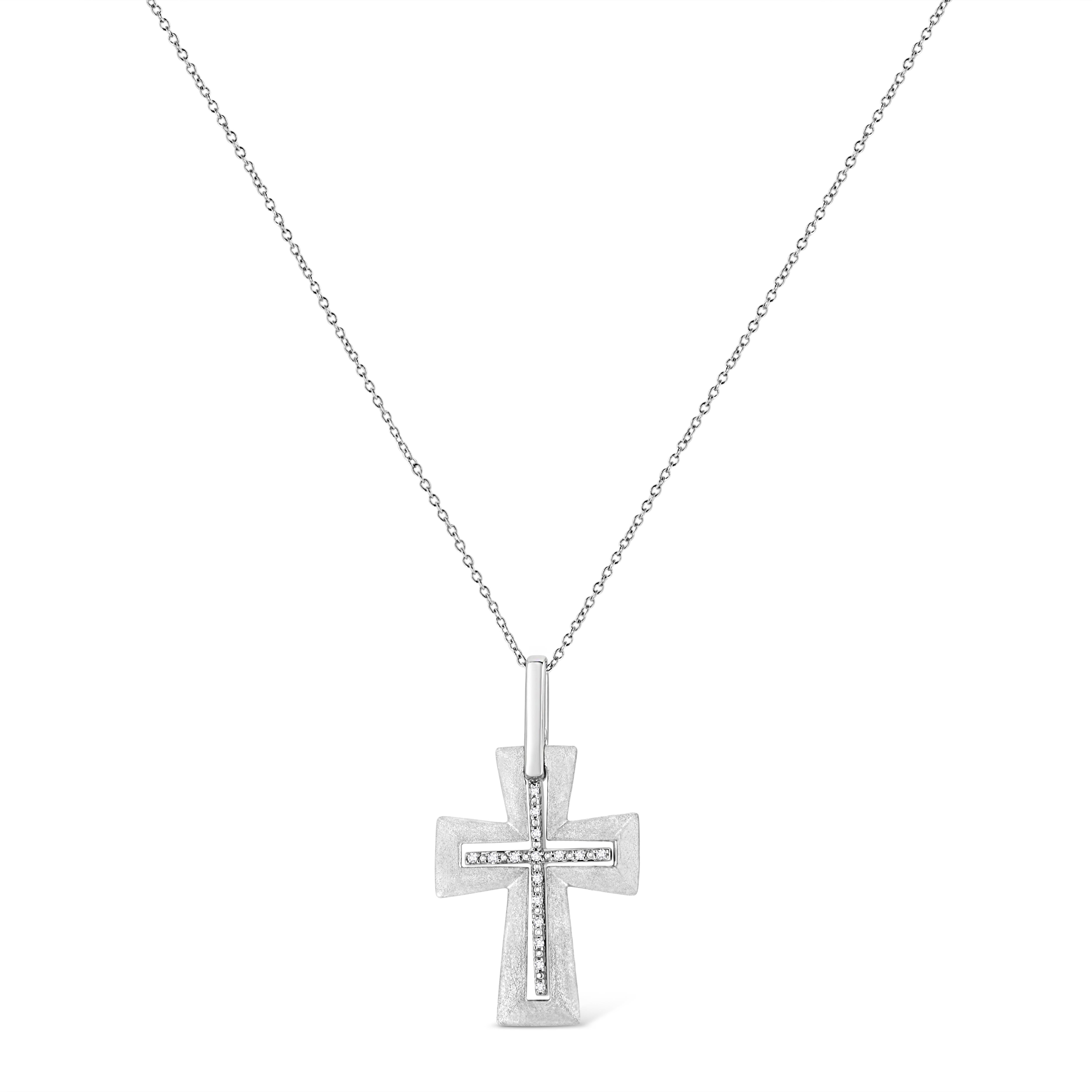Ce pendentif religieux en forme de croix de diamant est un symbole de foi étincelant. Habillé d'argent sterling étincelant, ce pendentif est orné de 16 radieux diamants ronds sertis à la pointe, disposés autour de la croix. Il est suspendu à une