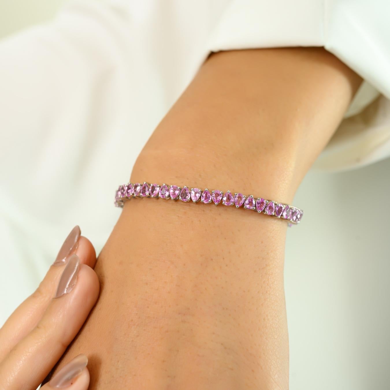 Dieses atemberaubende Tennisarmband aus leuchtendem 14-karätigem Weißgold verleiht Ihrer Schmucksammlung einen Hauch von femininer Eleganz. Die schillernde Anordnung der rosafarbenen Edelsteine im Birnenschliff mit einem Gesamtgewicht von 9,25 Karat