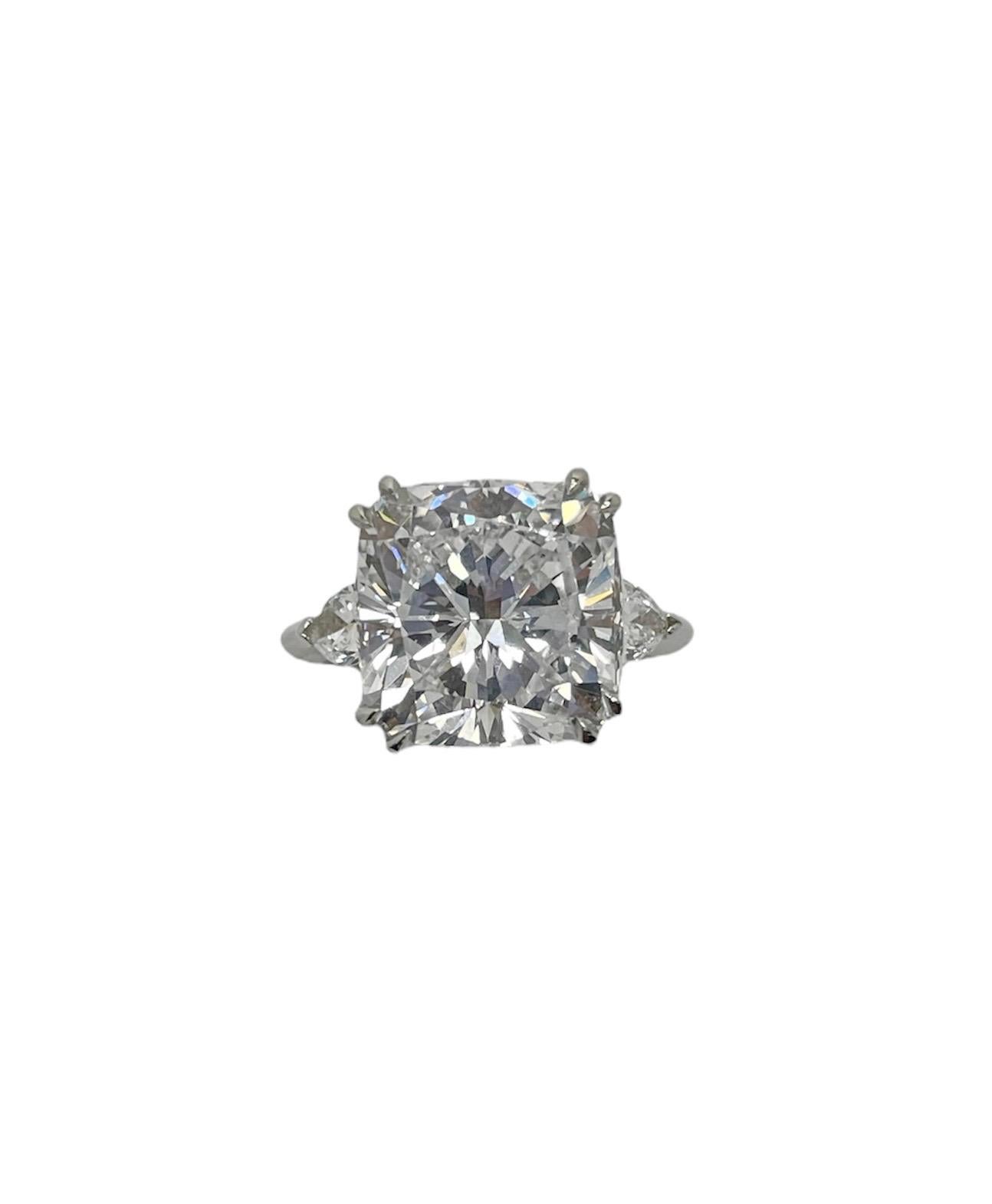This absolutely stunning ring features a 9.27 carat cushion modified brilliant cut diamond with D color and SI1 clarity, flanked by pear shaped diamonds weighing approximately 0.80 carat total. Mounted in platinum and skillfully crafted, this ring