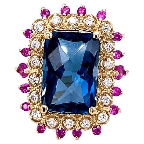 Beautiful to say the Least! 
This ring has a magnificent Emerald Cut 8.32 Carat London Blue Topaz is surrounded by 18 Round Cut Diamonds that weigh 0.38 Carats (Clarity: SI, Color: F) and 18 Pink Sapphires that weigh 0.60 Carats. The total carat