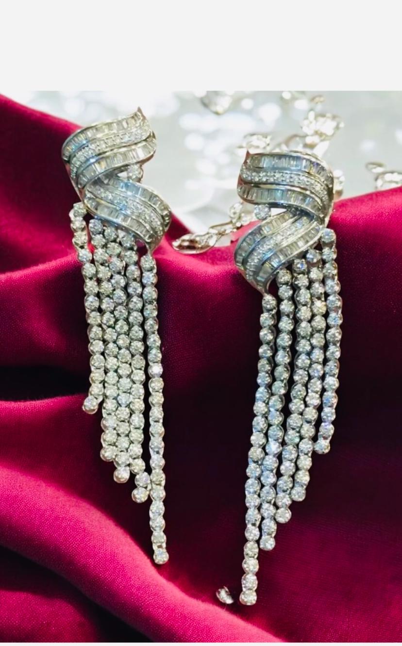IRRADIANDO ELEGANZA E RAFFINATEZZA, QUESTI ORECCHINI PENDENTI IN ORO BIANCO 14K SFOGGIANO 9,30 CARATI DI DIAMANTI TONDI E BAGUETTE METICOLOSAMENTE INCASTONATI. L'INCASTONATURA A PAVÉ NE ESALTA LA BRILLANTEZZA, RENDENDOLI IL TOCCO DI LUSSO PERFETTO